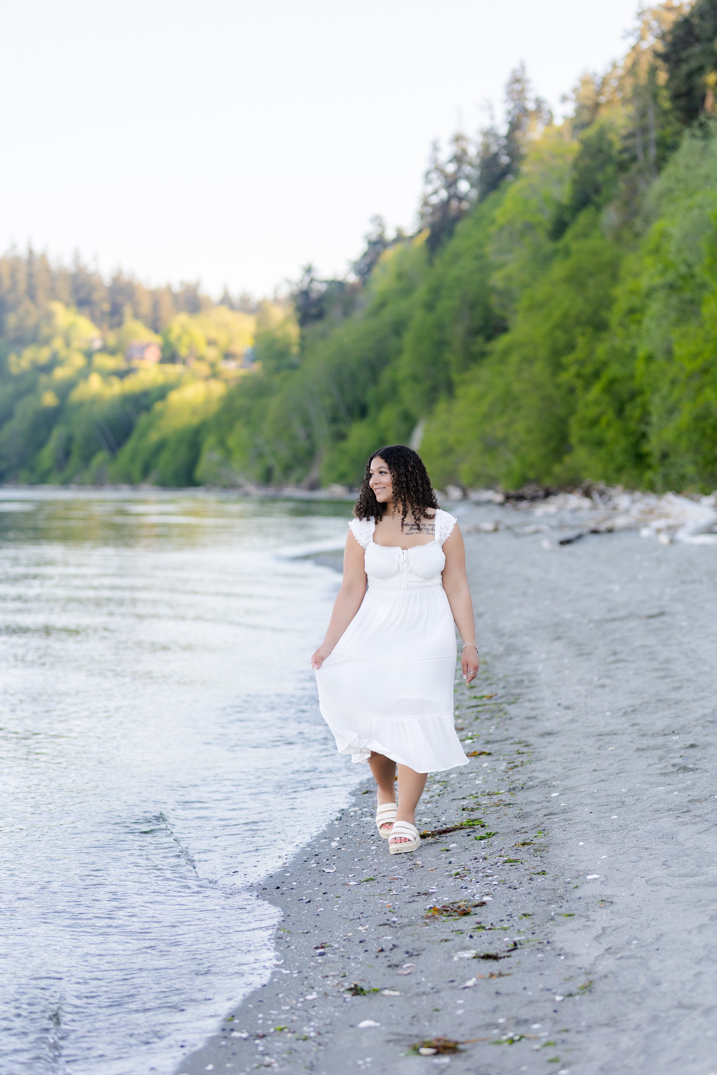 Senior picture of a girl from Stadium High School walking along the water on a North Kitsap beach