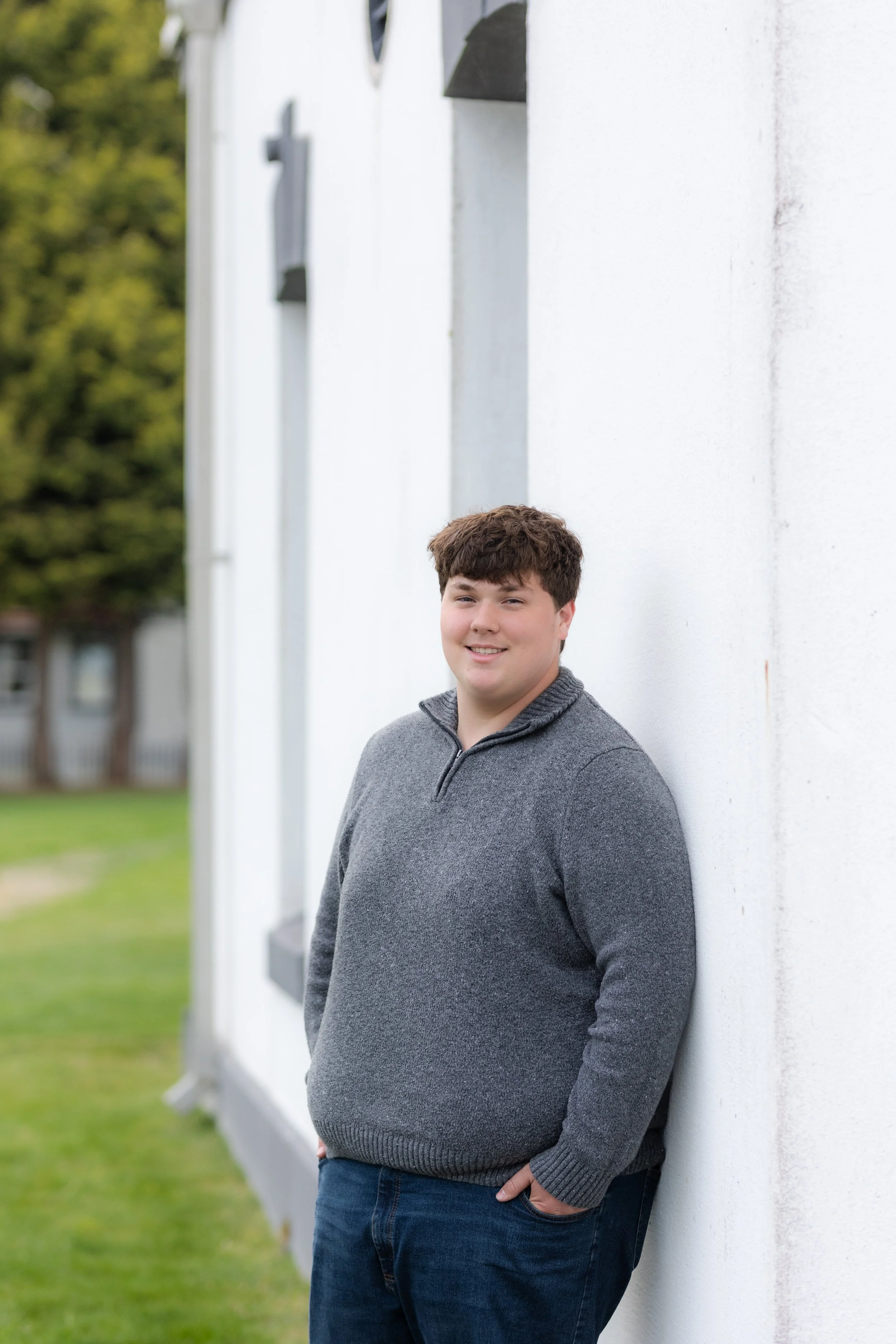 Senior photo of a boy taken against the lighthouse at Point No Point