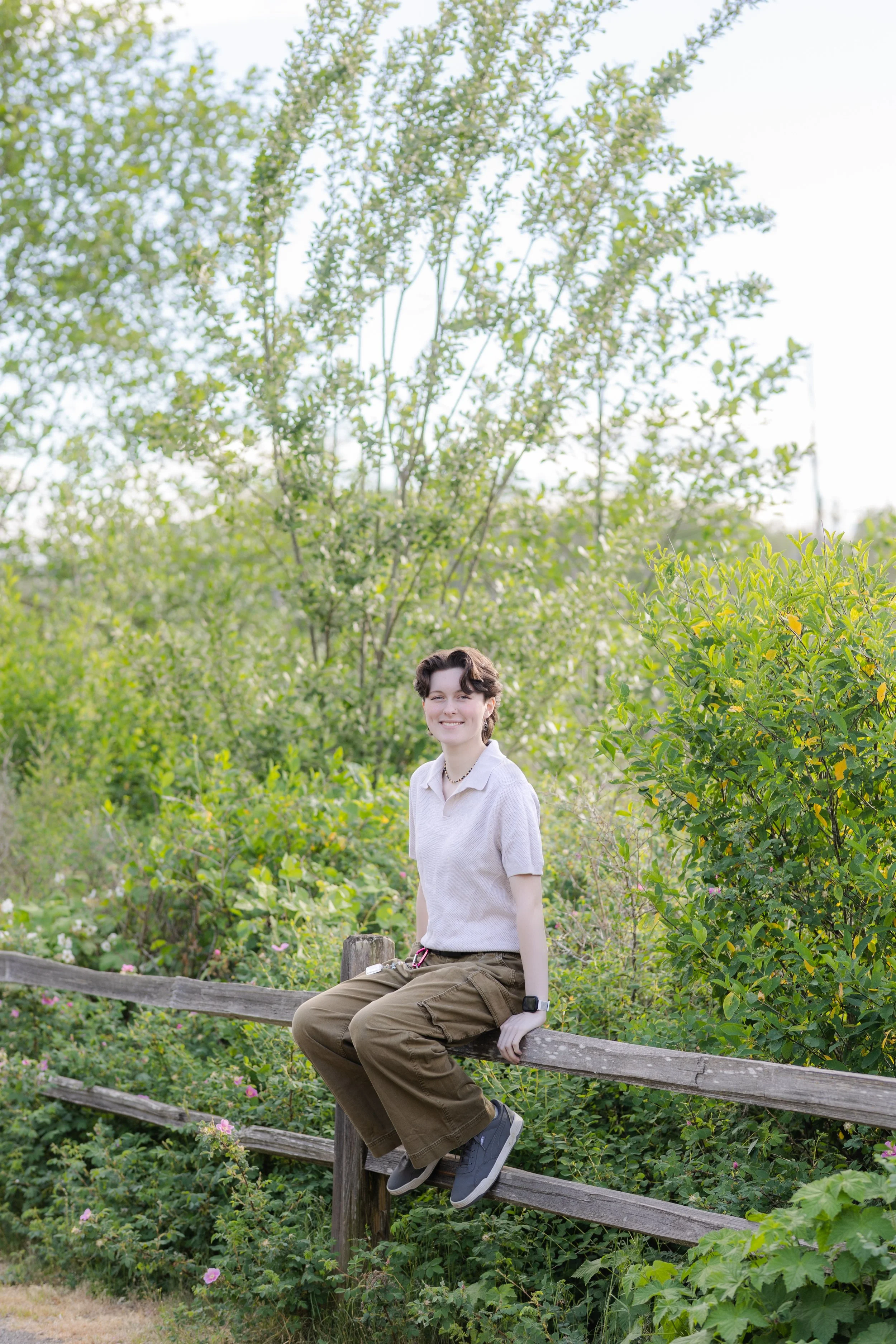 Senior picture of a girl sitting on a wooden fence in Silverdale, Washington