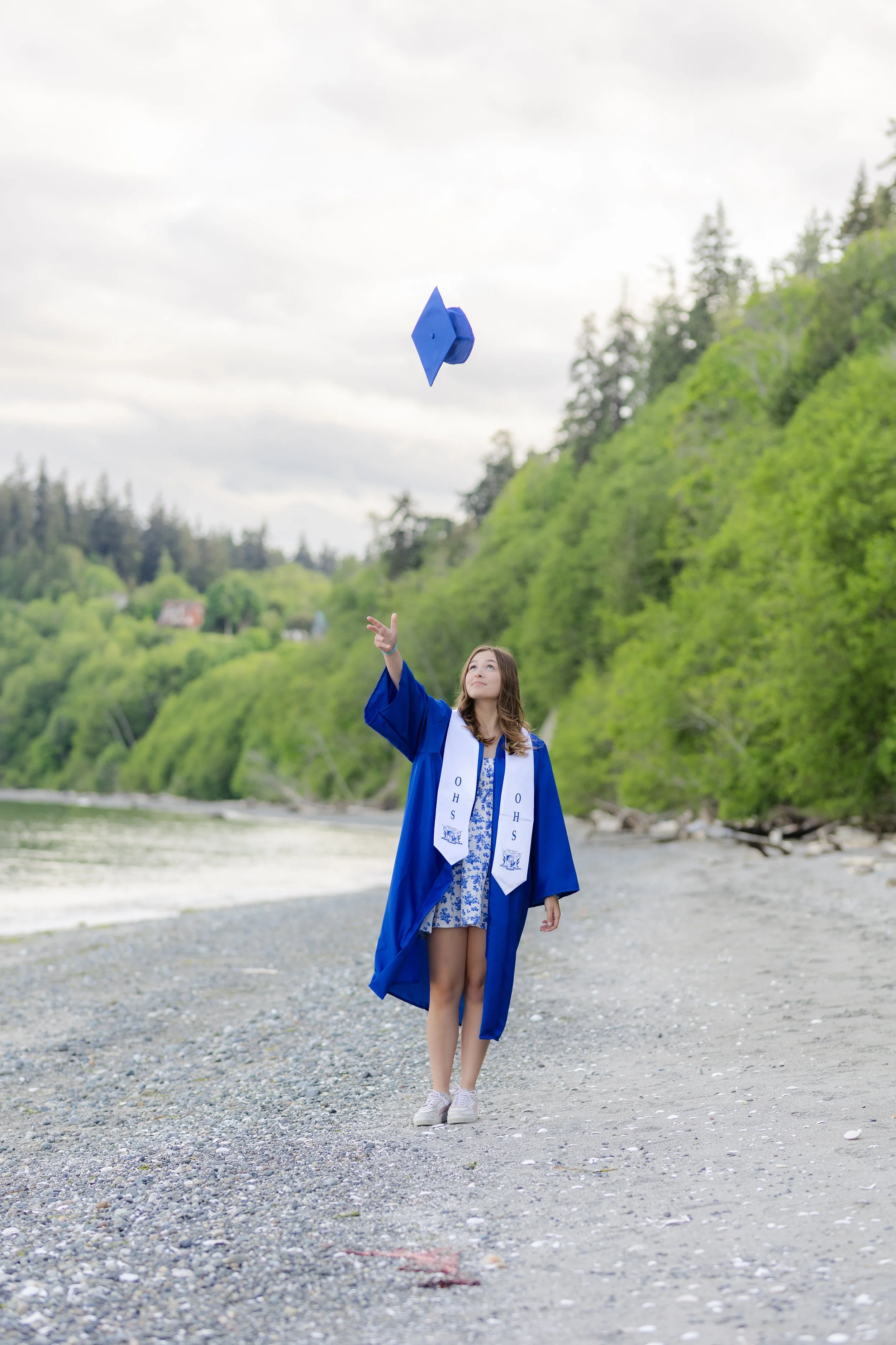 Olympic high school senior tossing her cap for graduation picture on the beach at Point No Point