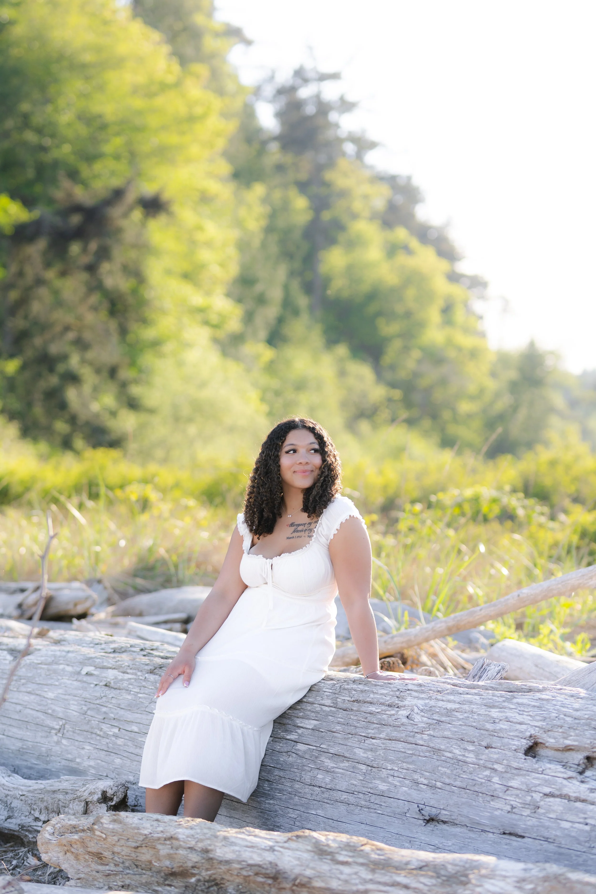 Kitsap senior picture of senior sitting on driftwood in a white dress