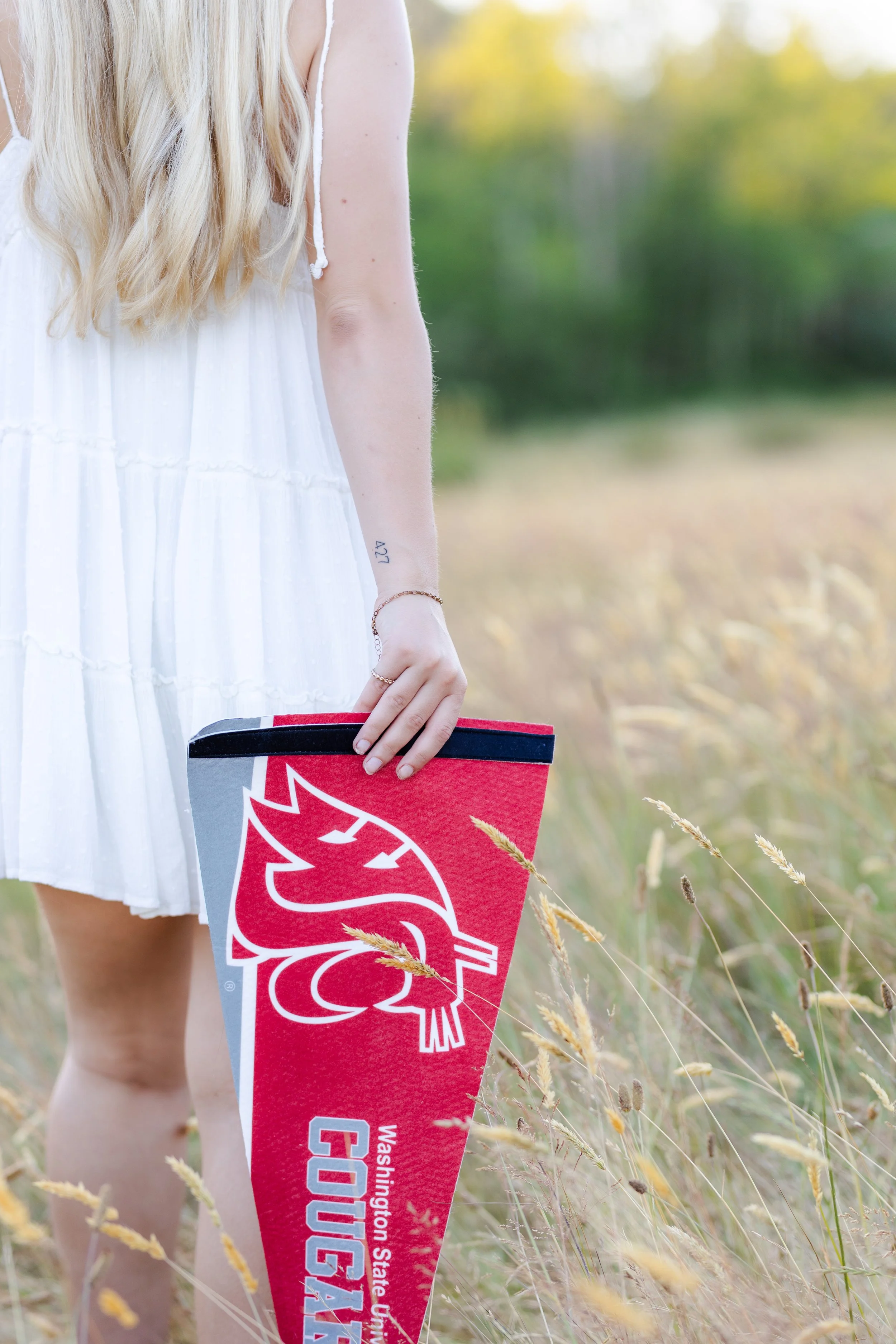 Washington graduation picture taken in a grassy field