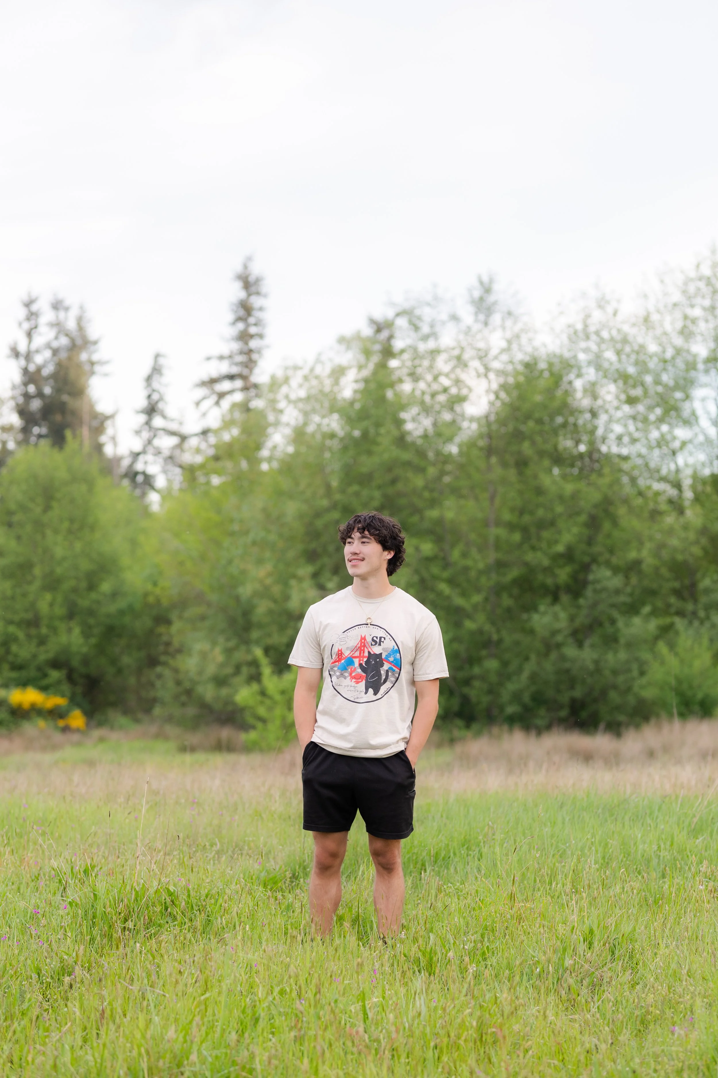 Kitsap senior picture of a boy standing in a grassy Silverdale field