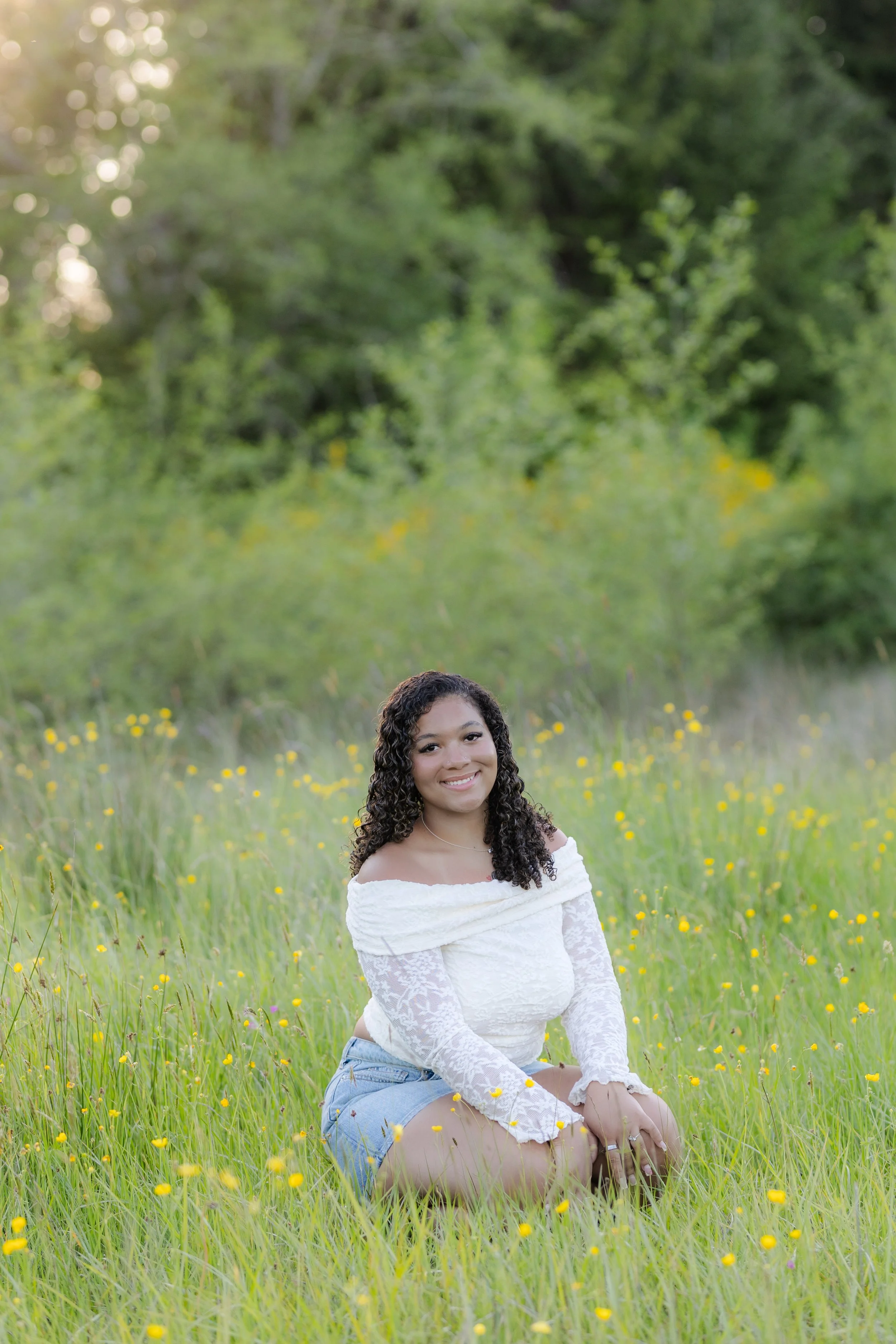 Senior photo of a girl in a green grass field with yellow flowers in Port Orchard, WA