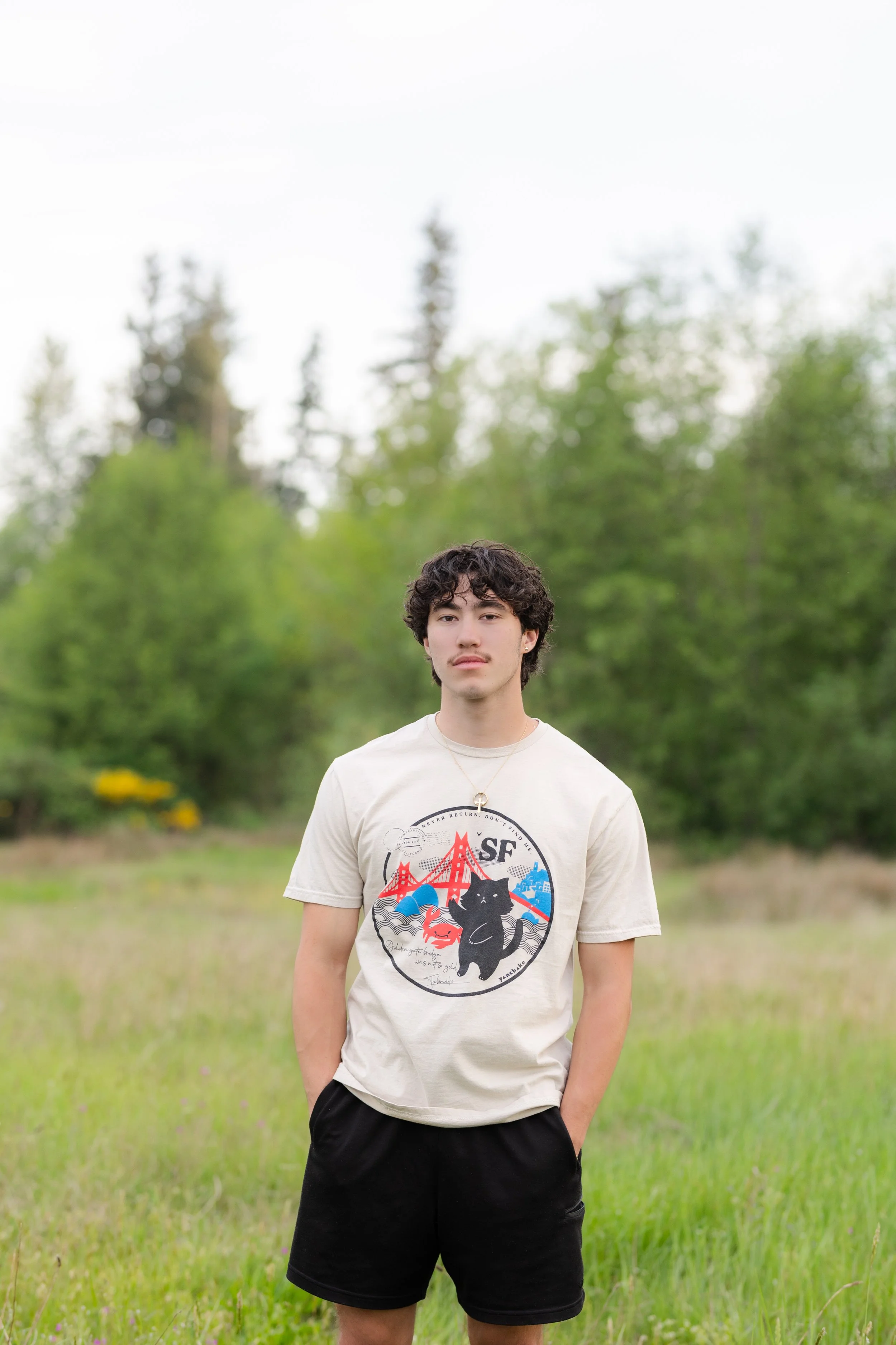Kitsap senior picture of a boy standing in a grassy Silverdale field