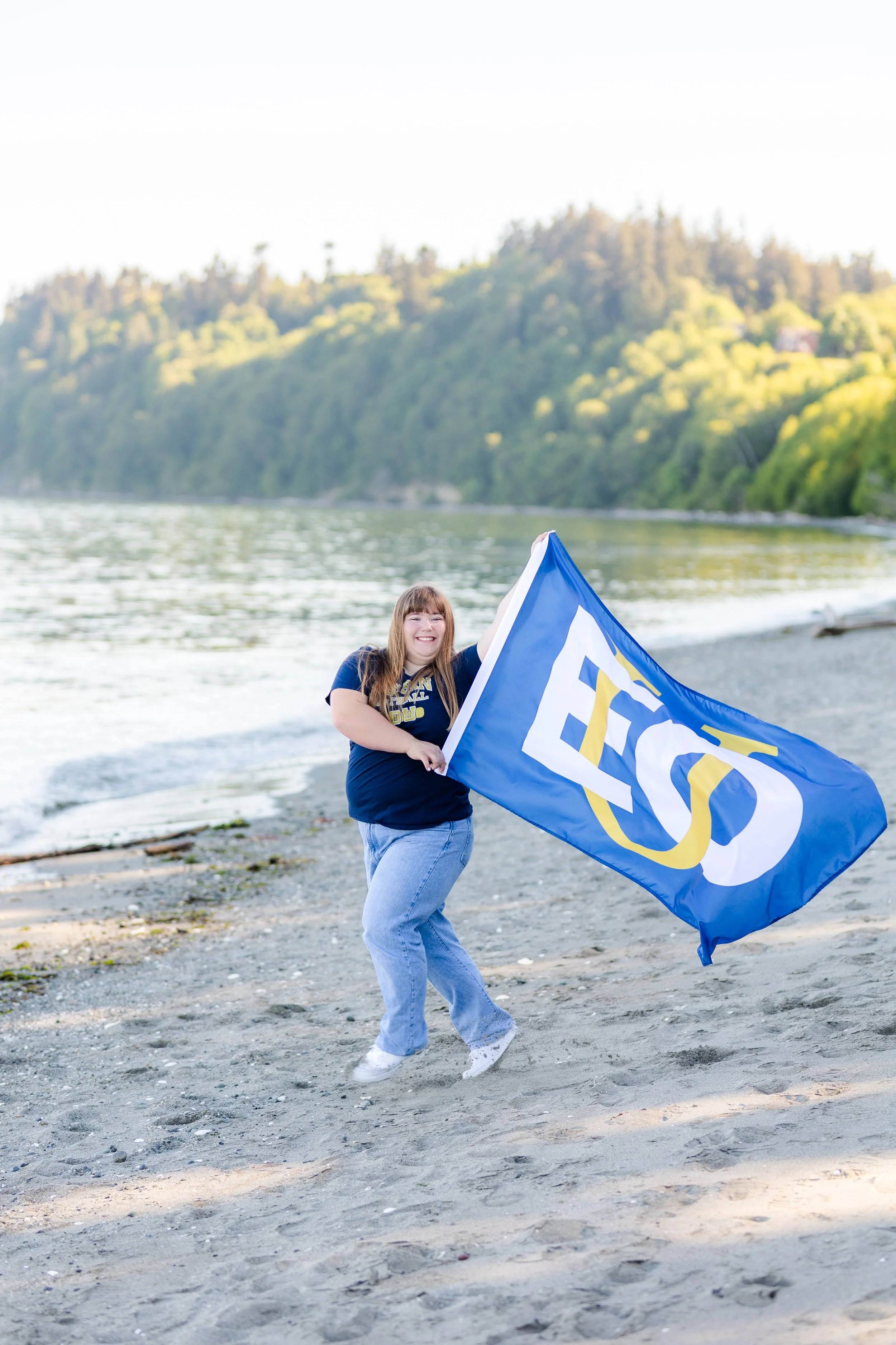 Senior picture of girl running with a large flag for Eastern Oregon University