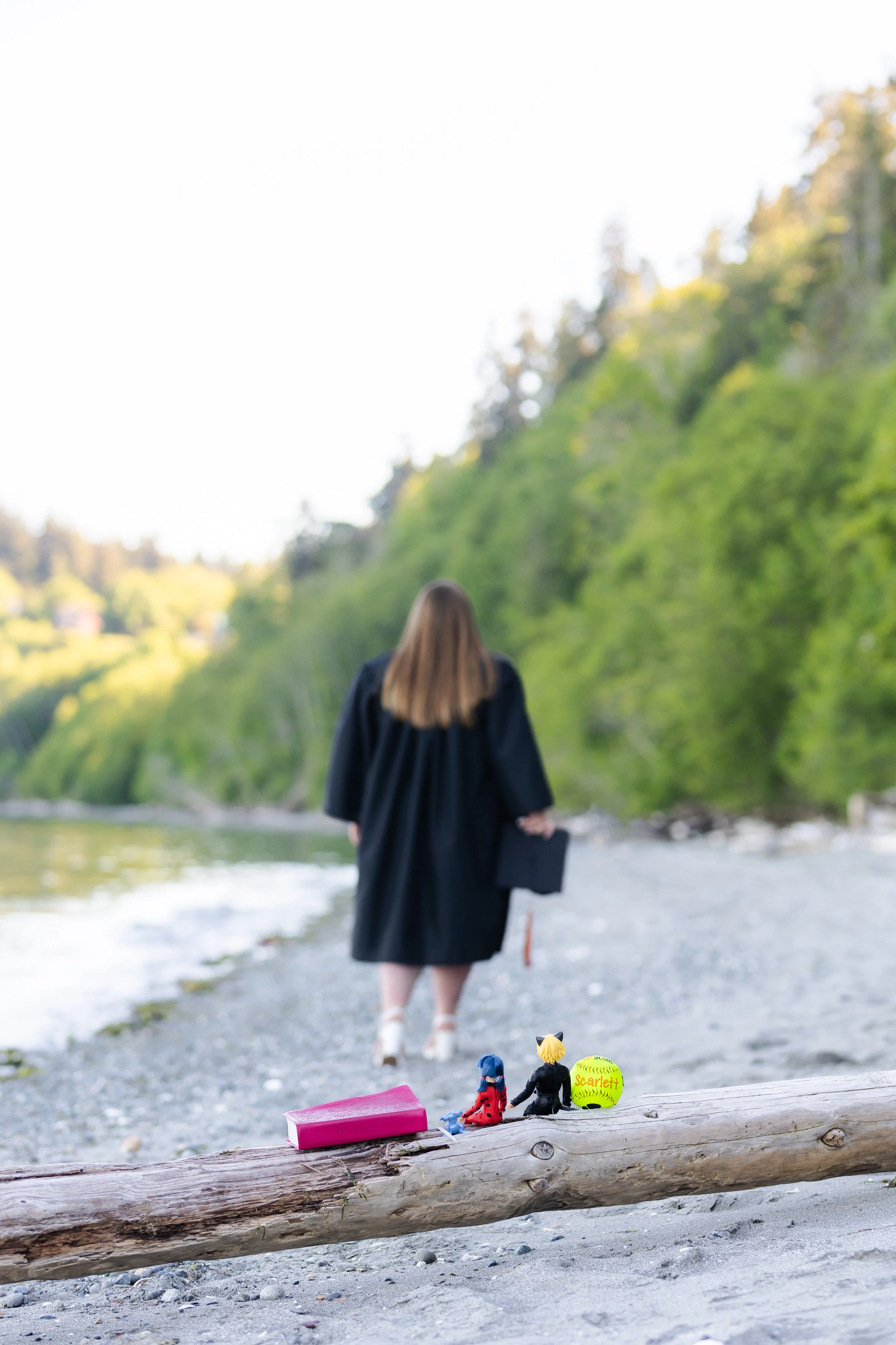 Graduation picture of senior walking away from childhood toys in her cap and gown