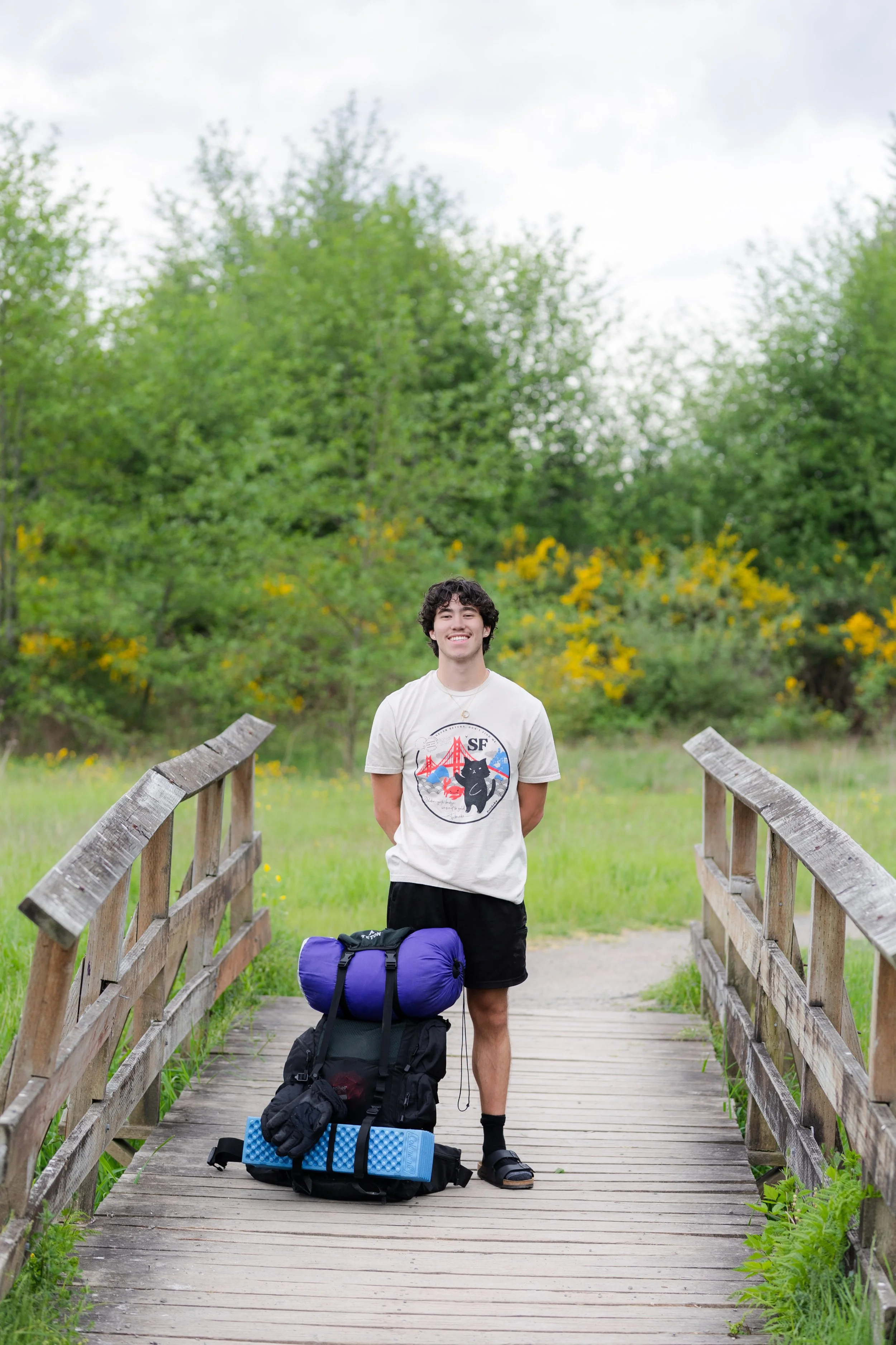 Senior picture of a boy standing with his backpacking backpack in Washington