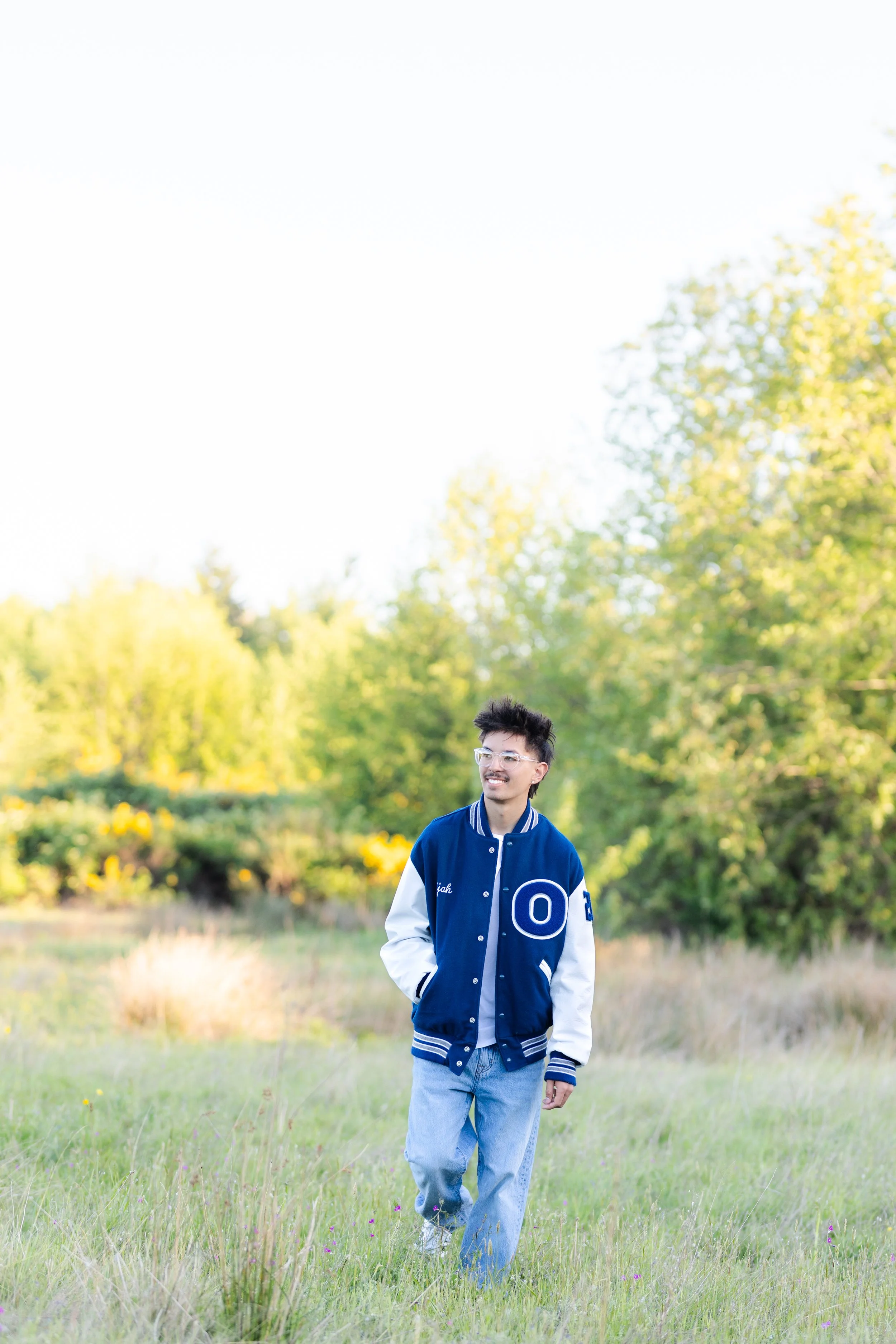 Senior picture of an Olympic High School senior walking in his letterman jacket