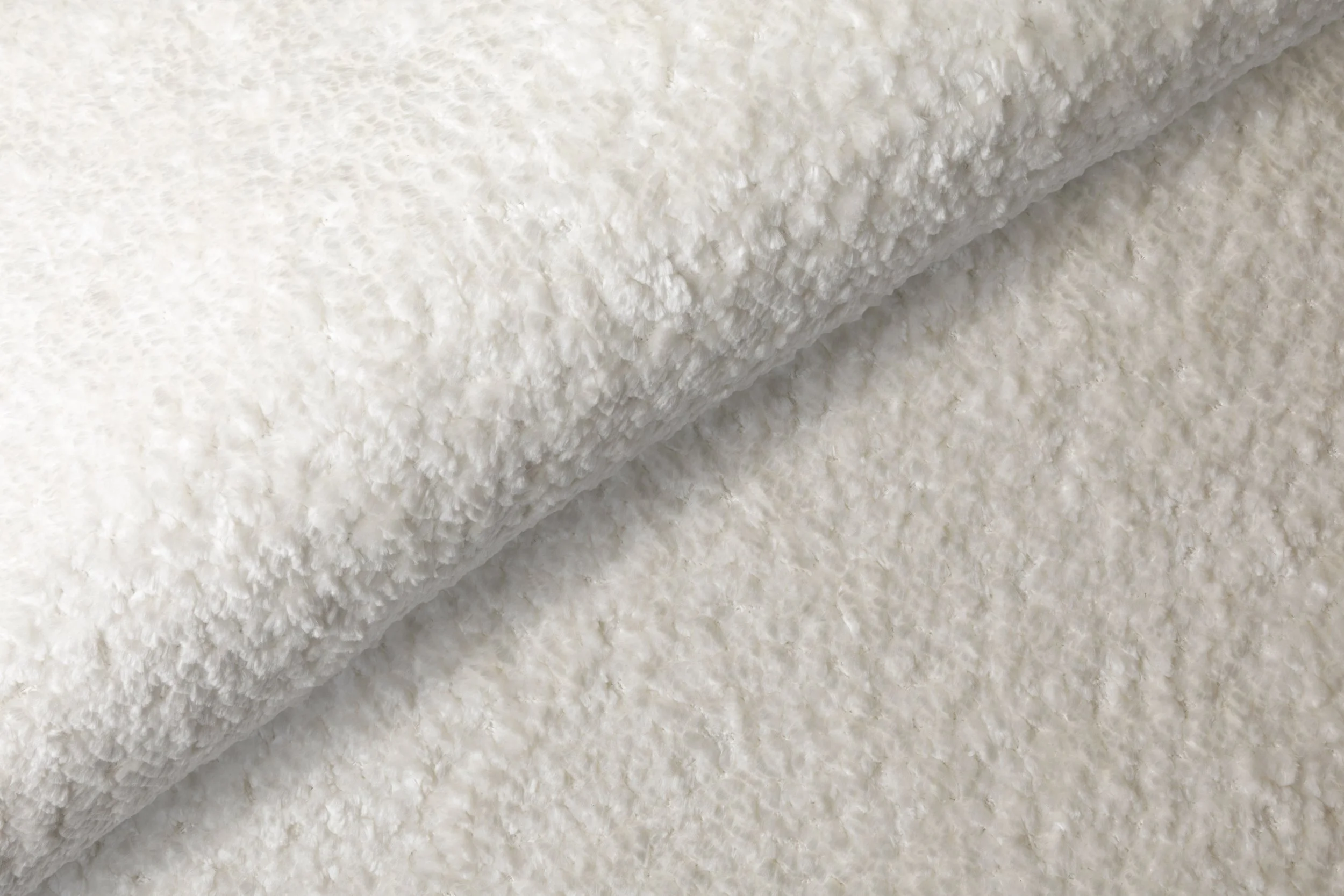 Närbild av ett fluffigt, vitt ulltyg eller fleece-material.