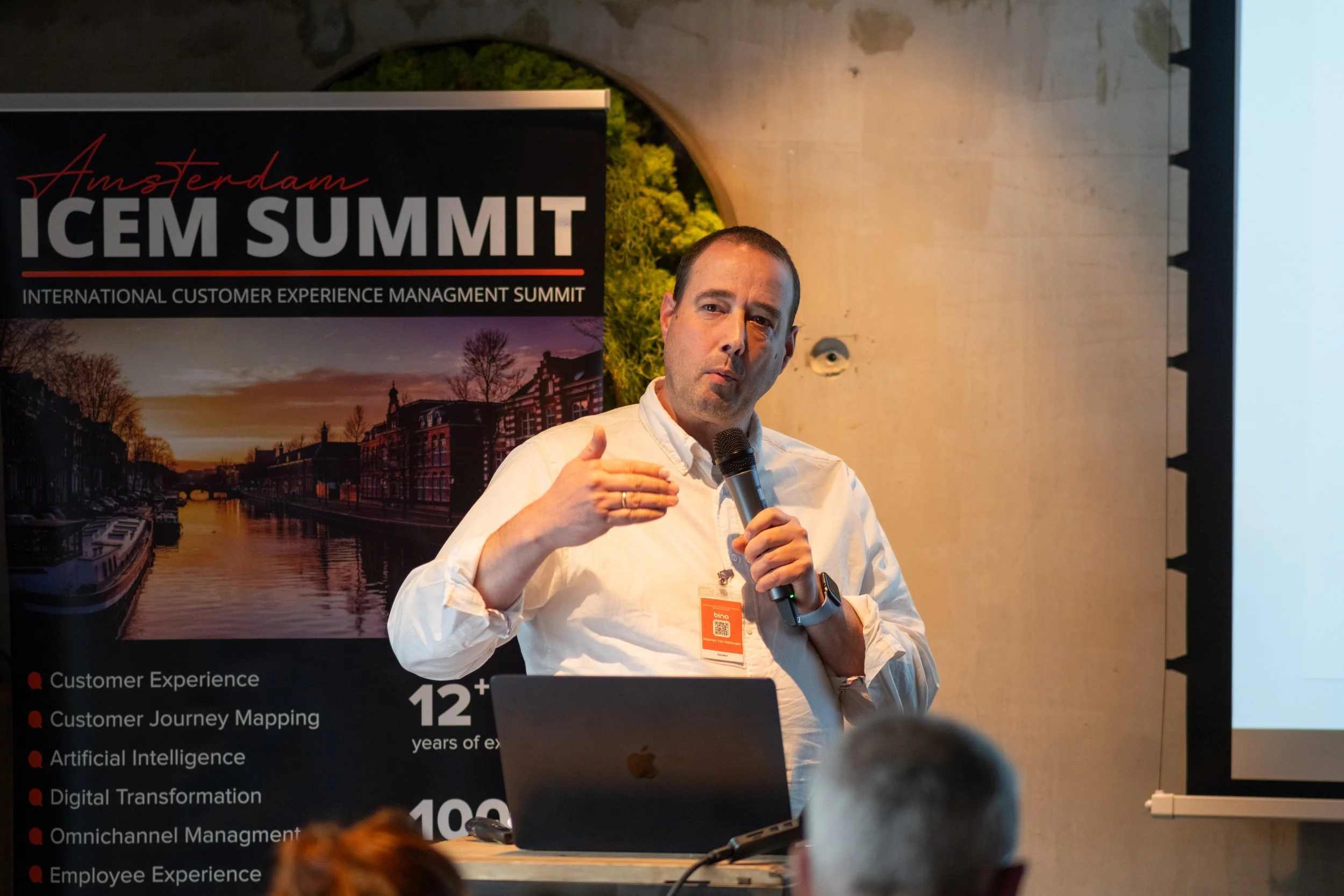 Maarten van Heiningen presenting during an event holding a microphone and talking to a crowd