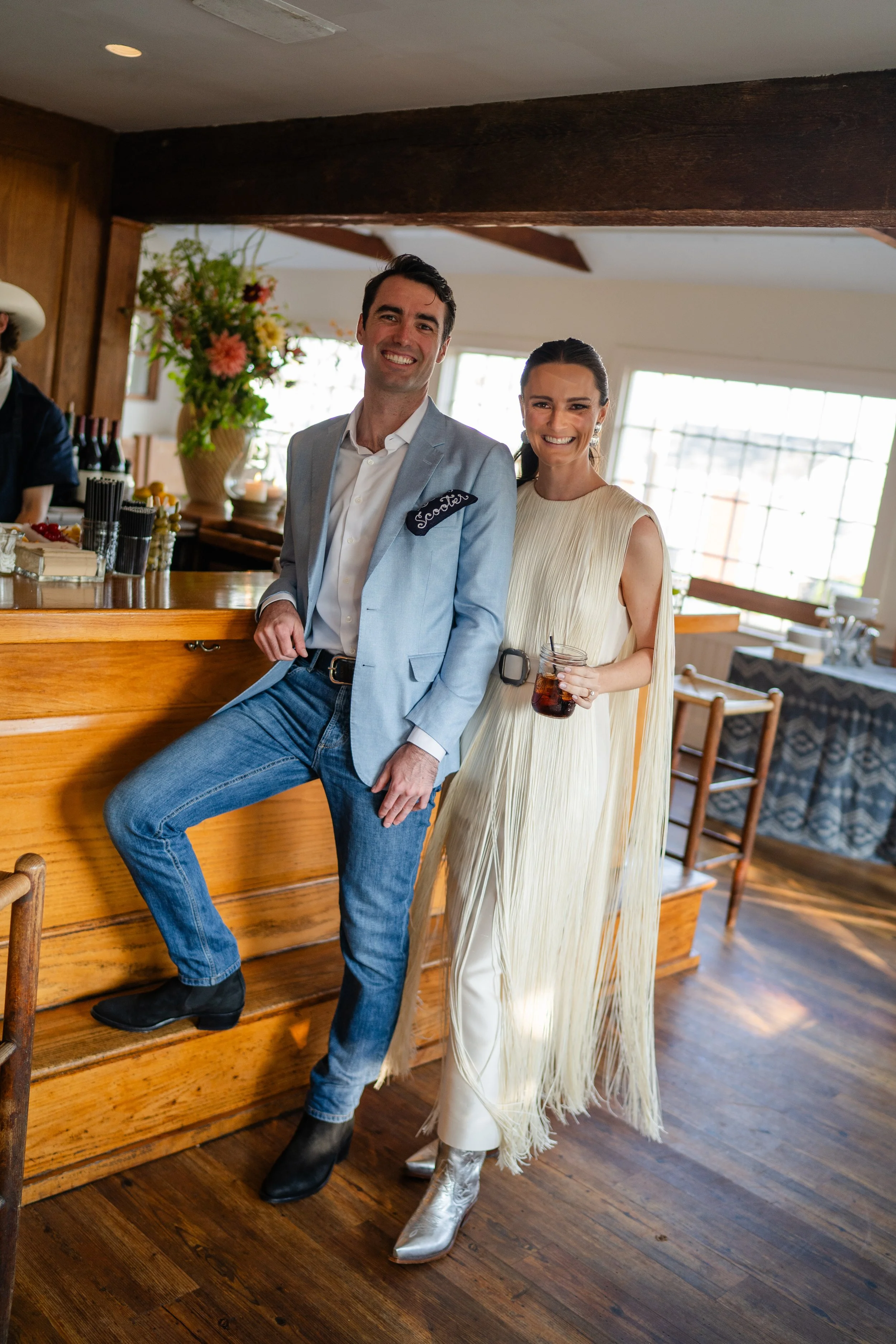 The bride and groom, the groom is wearing jeans and a light blue jacket with a navy blue custom chainstitch bandana in the pocket with his name Scooter embroidered in white thread.