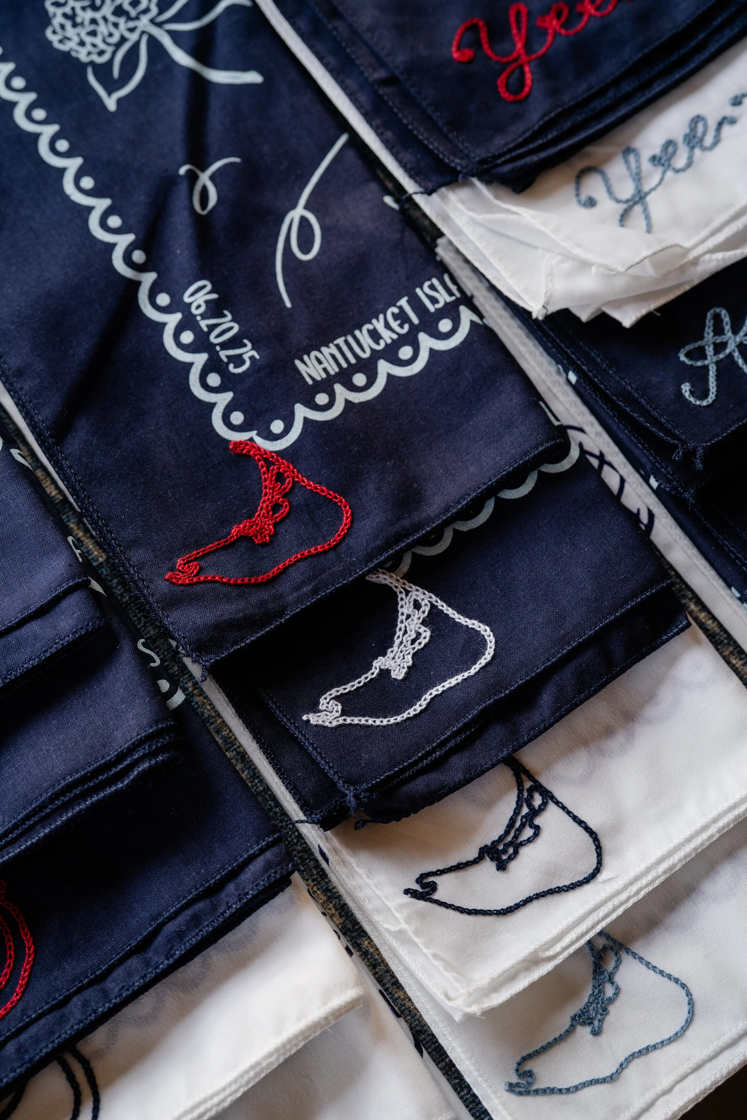 Custom chainstitch bandanas embroidered with the outline of Nantucket Island. The bandanas are navy blue and white with the Nantucket logo red, white, navy blue, and marine blue.