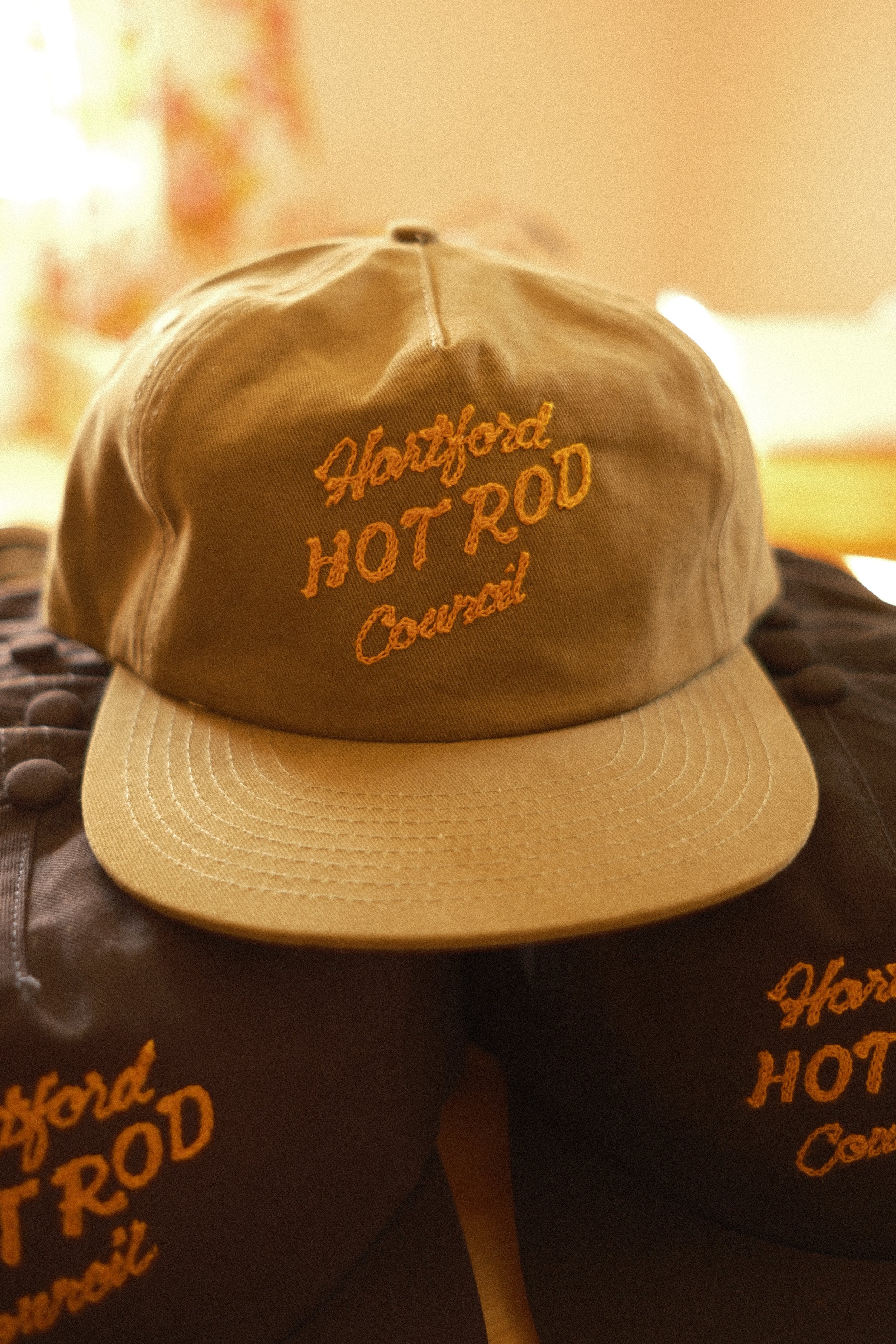 A stack of three trucker hats each reading "Hartford Hot Rod Council" in gold chainstitch embroidery