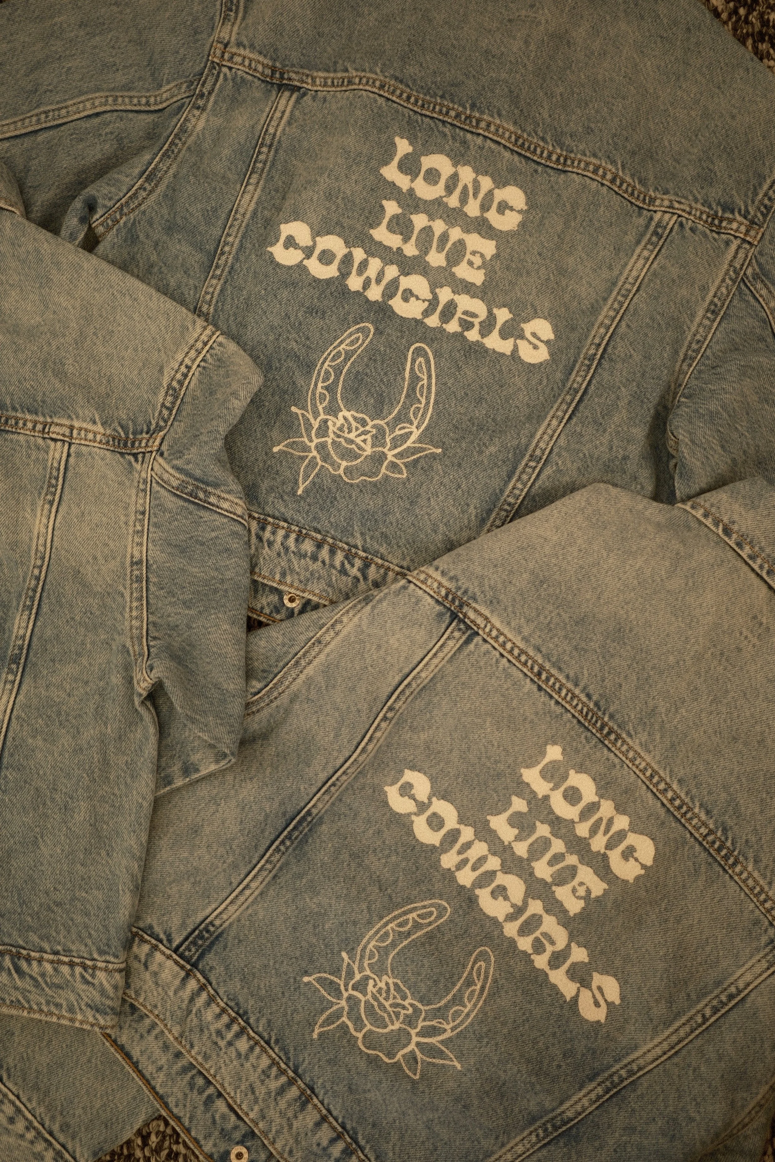 Three denim jackets with chainstitch embroidery reading "Long Live Cowgirls" and an embroidered horseshoe with a rose