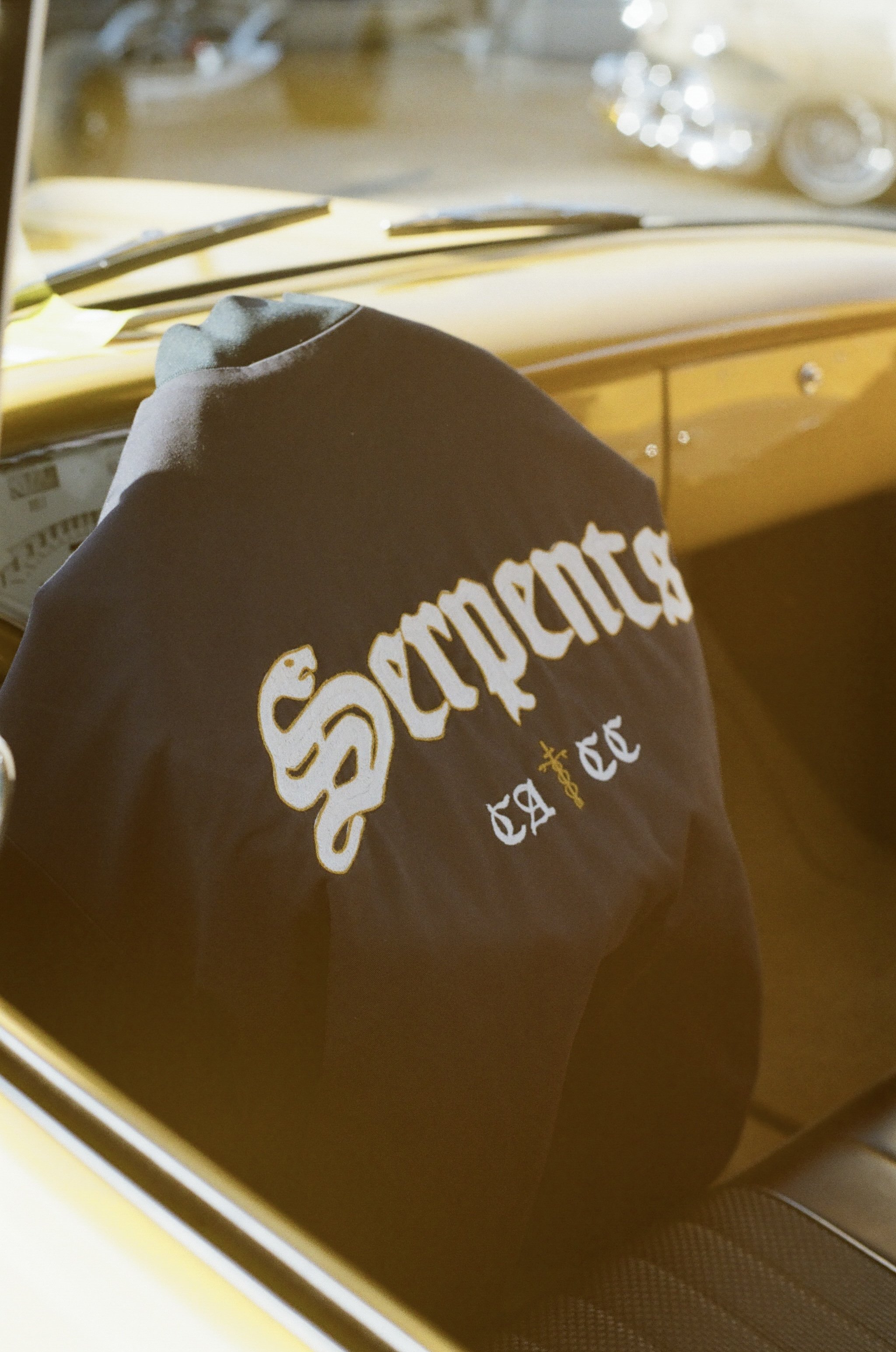 A navy blue chainstitch embroidered jacket with lettering from the car club "Serpents"