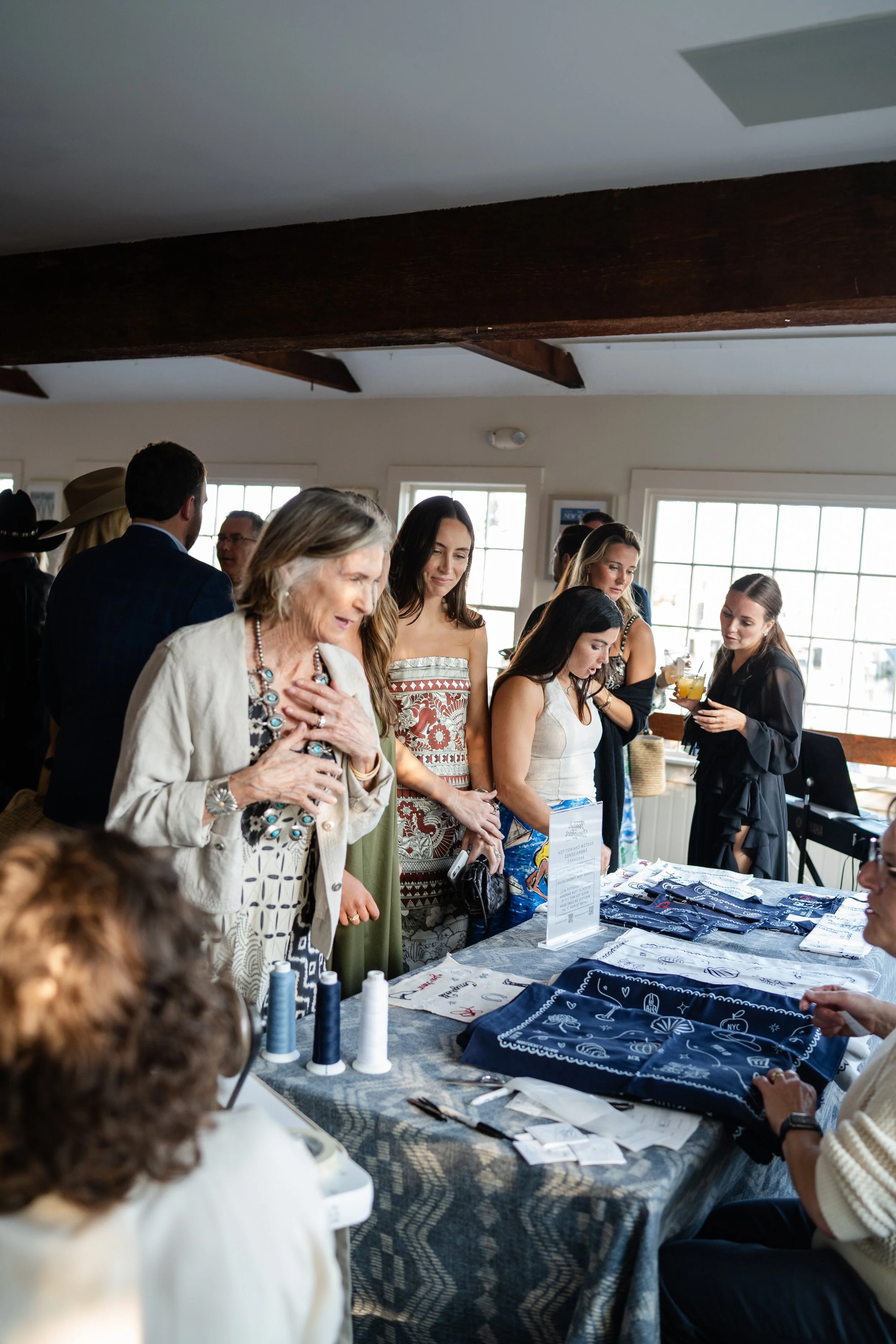 Wedding guests are lining up at the embroidery station to choose their bandana, thread color, and custom embroidery.