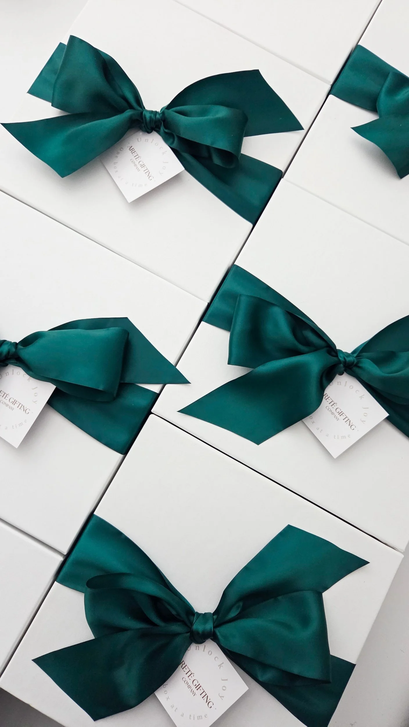 White boxes decorated with teal ribbons and tags, likely gift boxes.