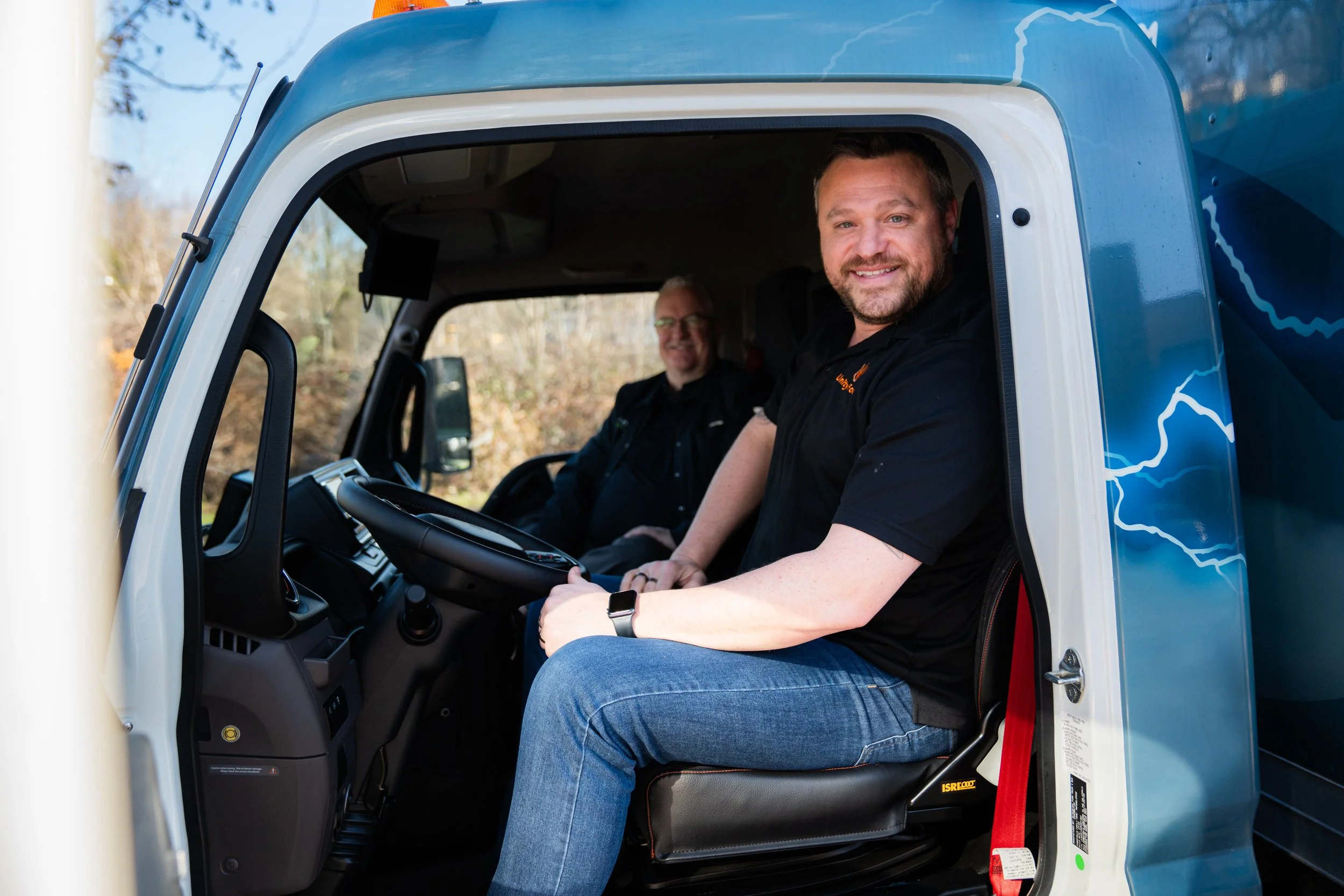 Man sitting in the cab of a heavy-duty electric truck