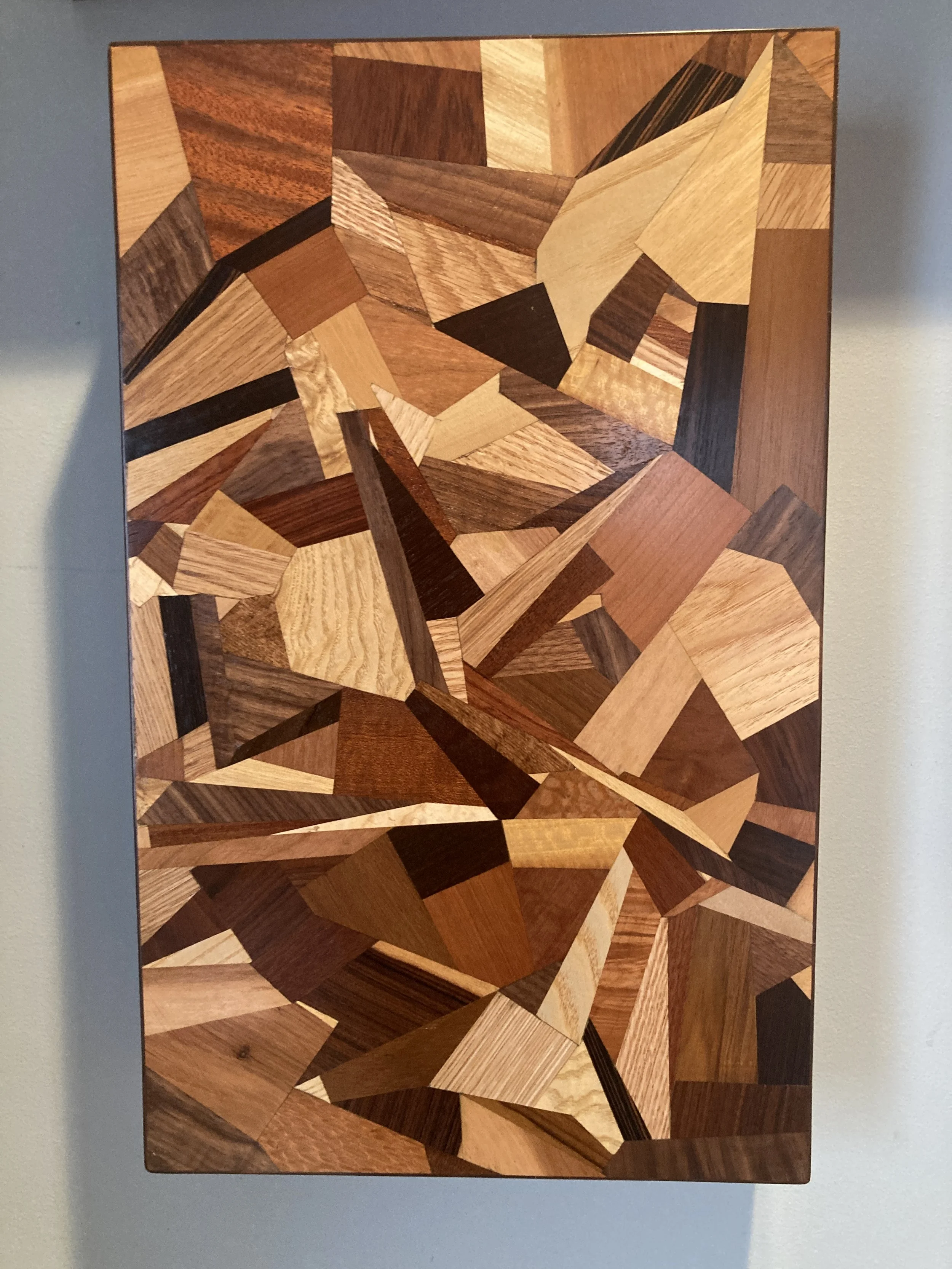 Abstract geometric wood art with various shapes and shades.