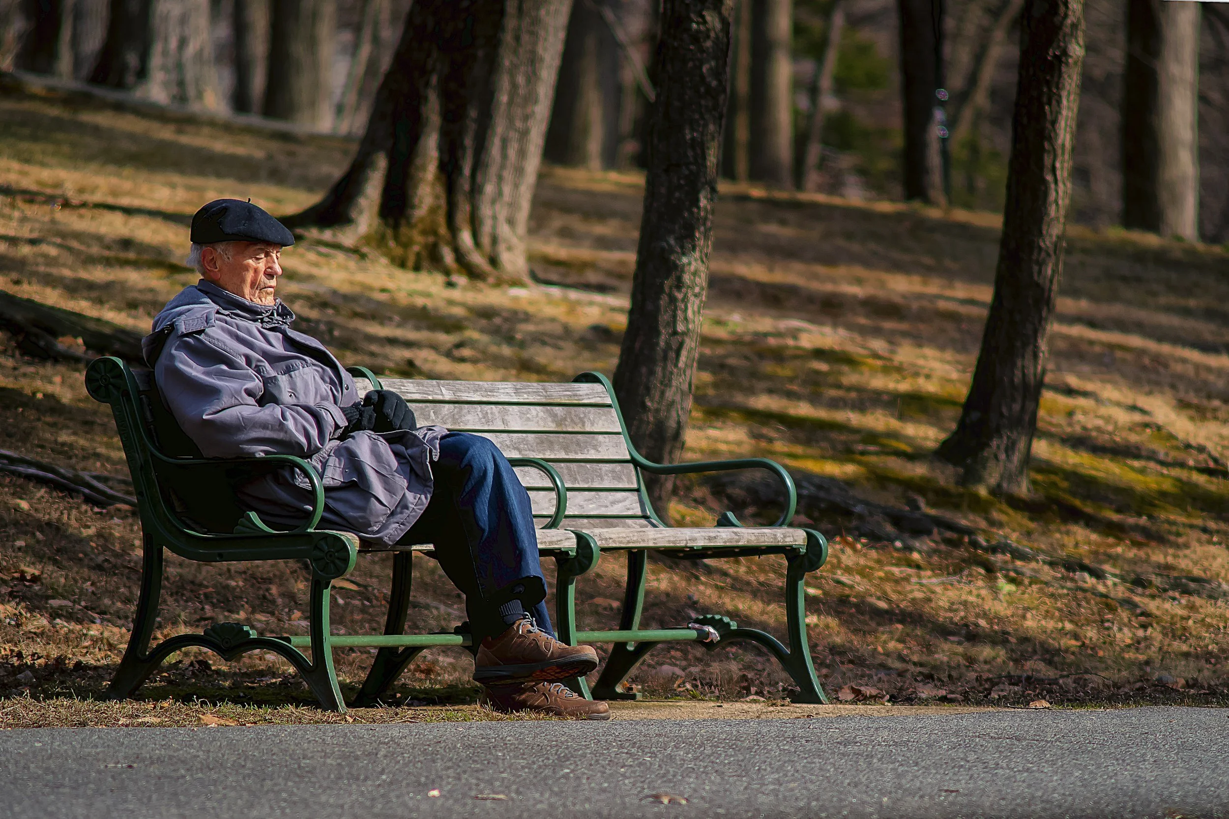 Older adult on park bench reflecting and recharging