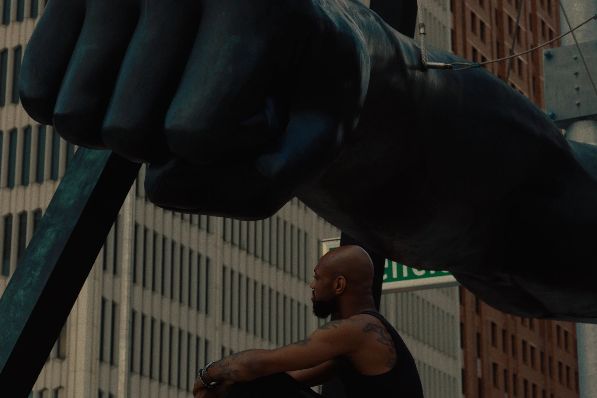 Image still from the short documentary film My Hands Purpose by Detroit based director John Sippel. Sculptor Austen Brantley sits by the Joe Louis Fist statue in downtown detroit.