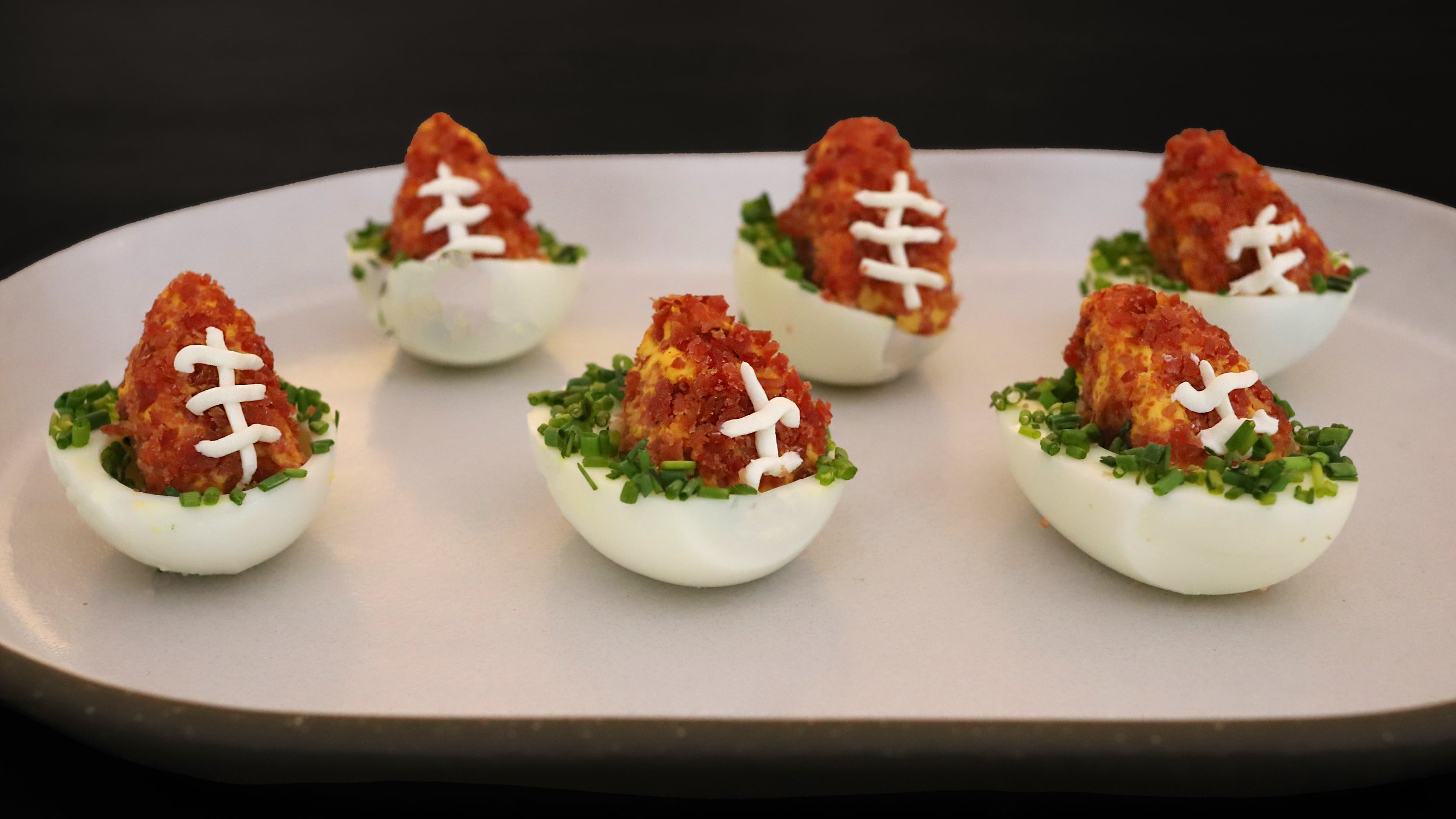 FOOTBALL-SHAPED DEVILED EGGS WITH TURKEY BACON CRUST &amp; CHIVE “FIELD”