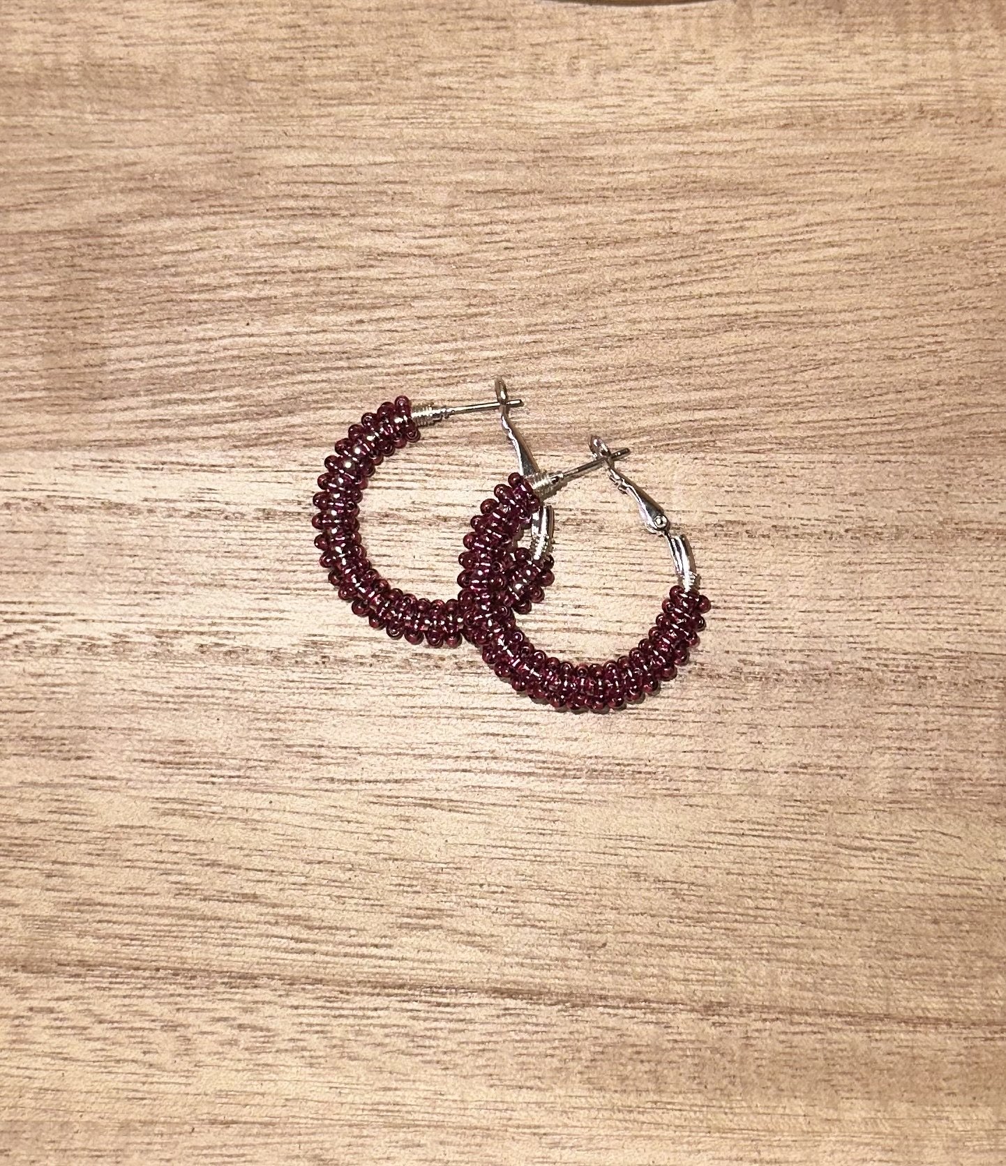 Mini maroon beaded hoops.