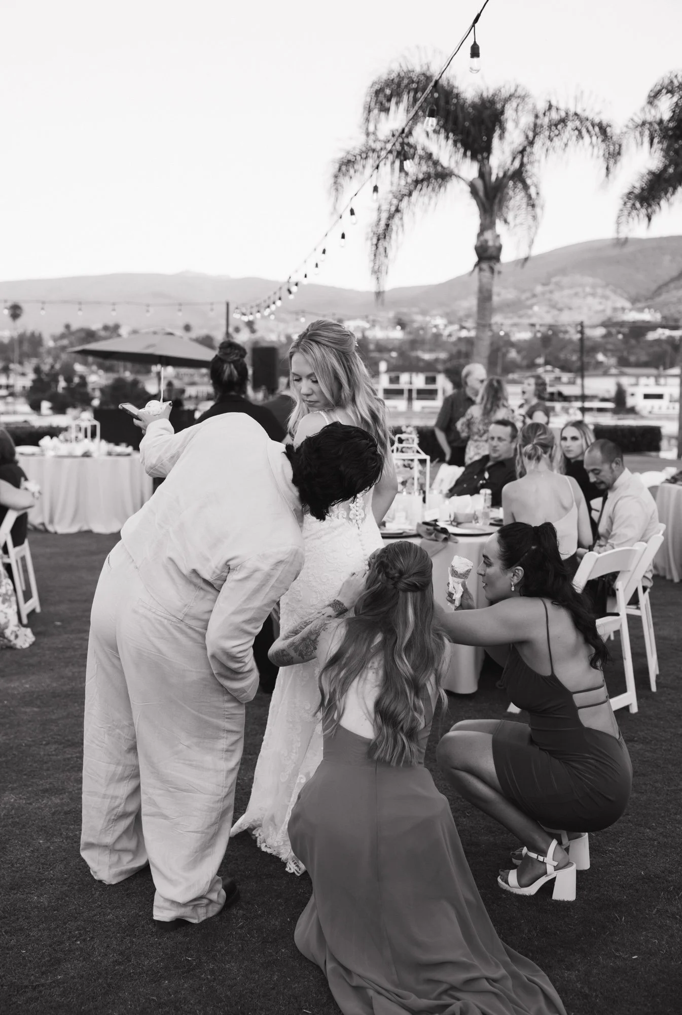 Candid photographer takes candid photo of bride and guest during her wedding at LakeHouse Resort in Lake San Marcos