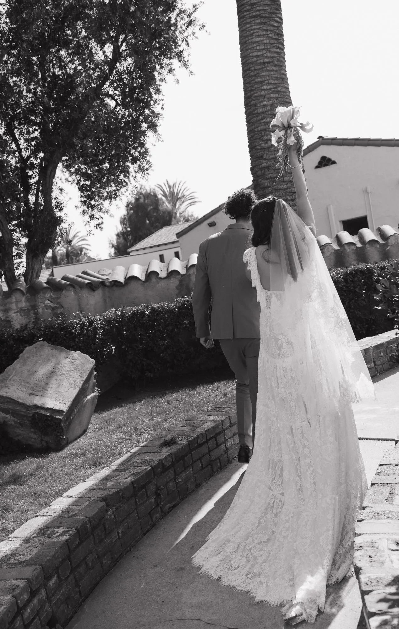 A candid photographer takes a candid photo of bride and groom as they walk on their wedding day in Los Angeles California.