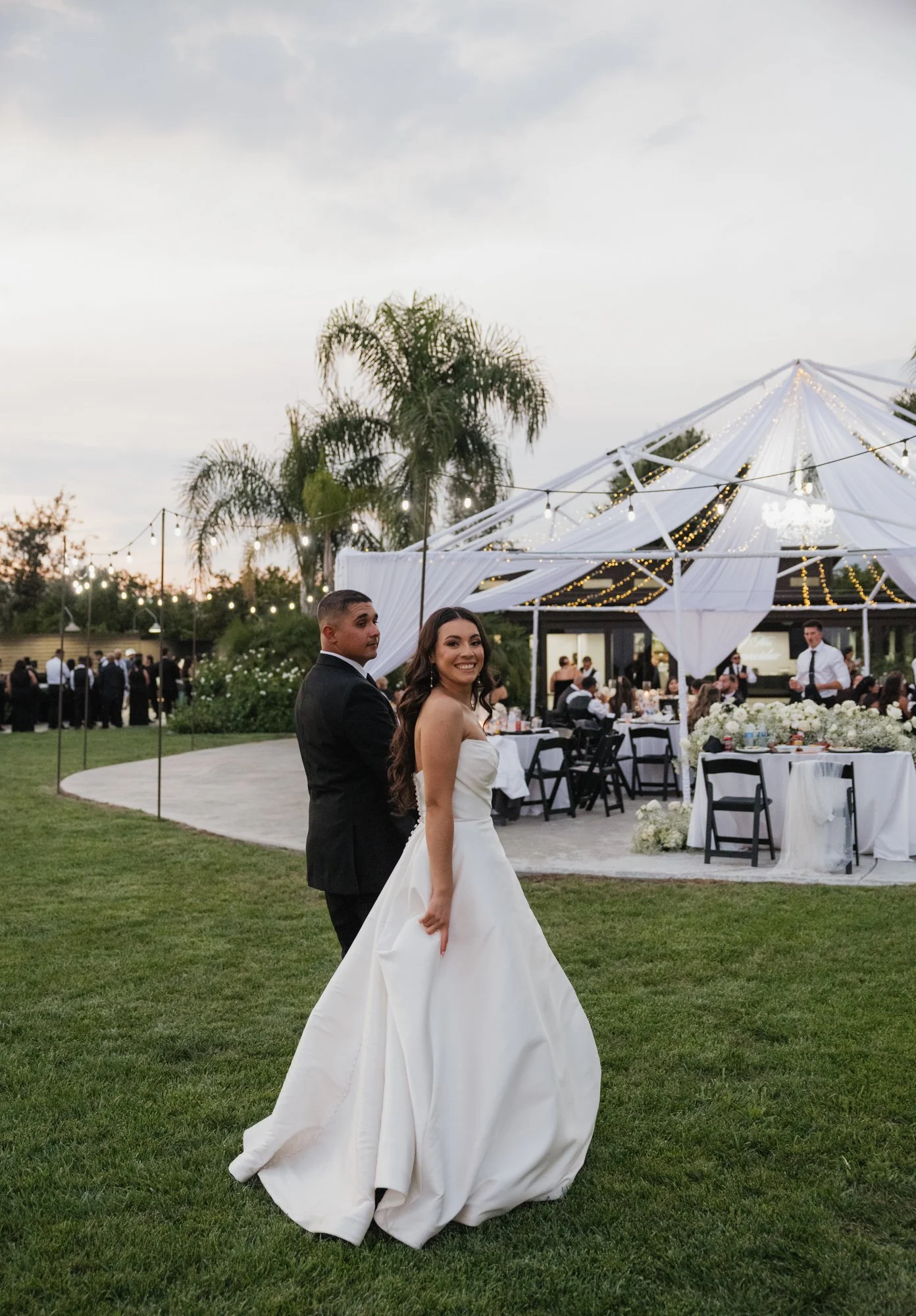 Candid moment of bride and groom walking back to reception during golden hour at The Grove Redlands in Southern California