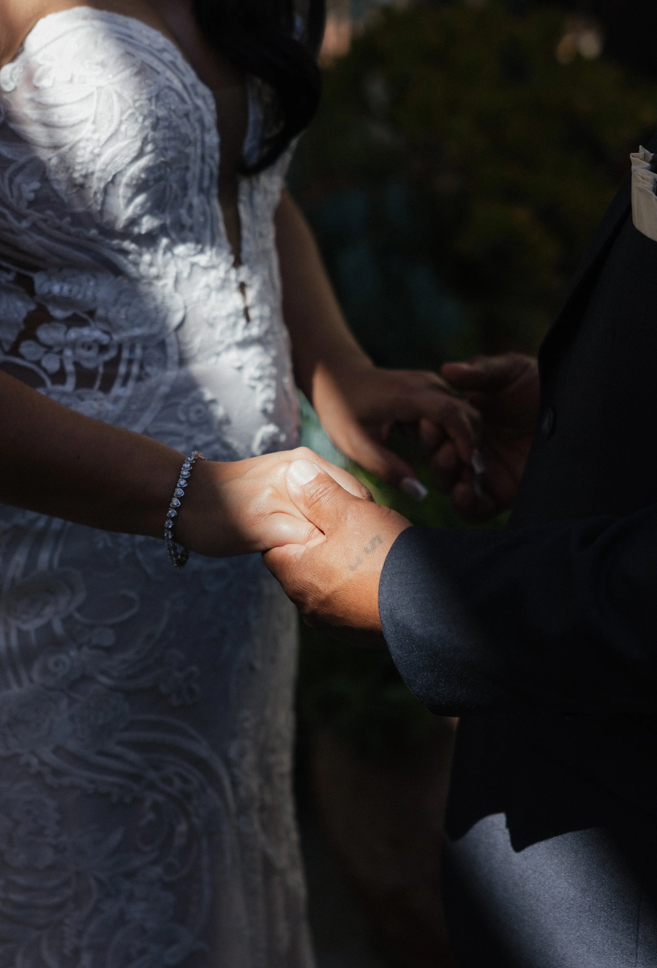 A candid photographer takes a detailed photo of bride and her dad holding hands on her wedding day in Los Angeles California.