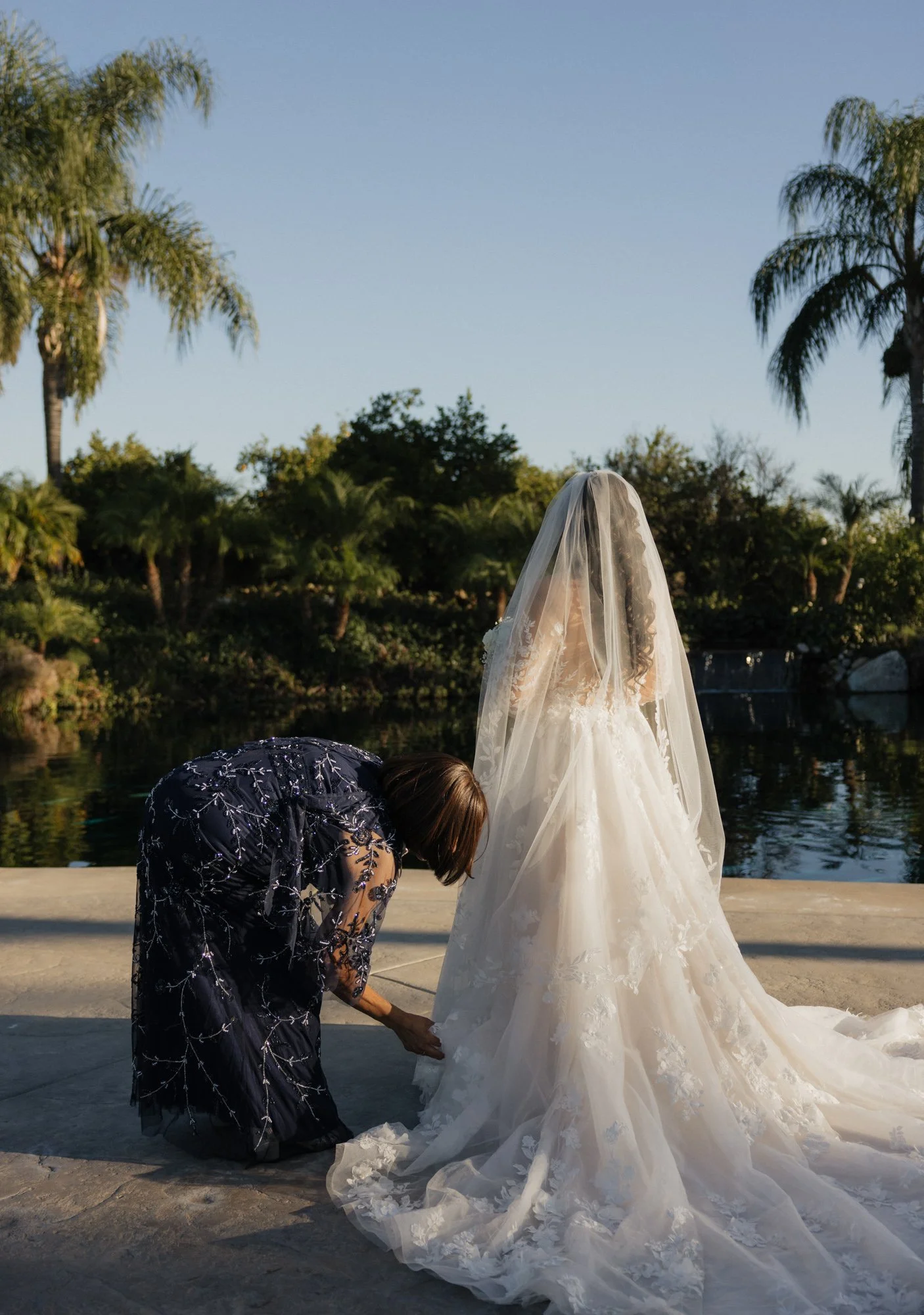 A candid photographer takes a candid photo of her mother in law helps with her dress in Redlands California.