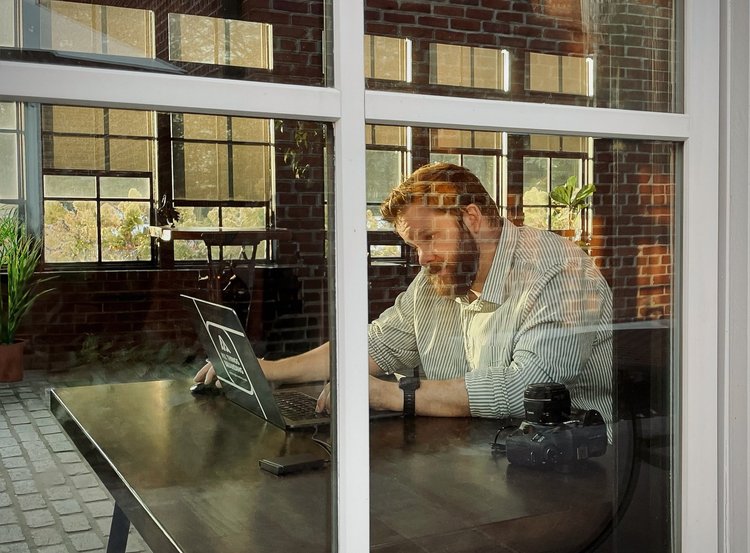 Anthony Williams working on a brand project by a studio window