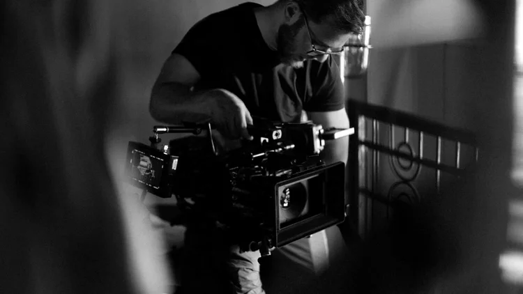 A camera operator carrying a cinema camera rig