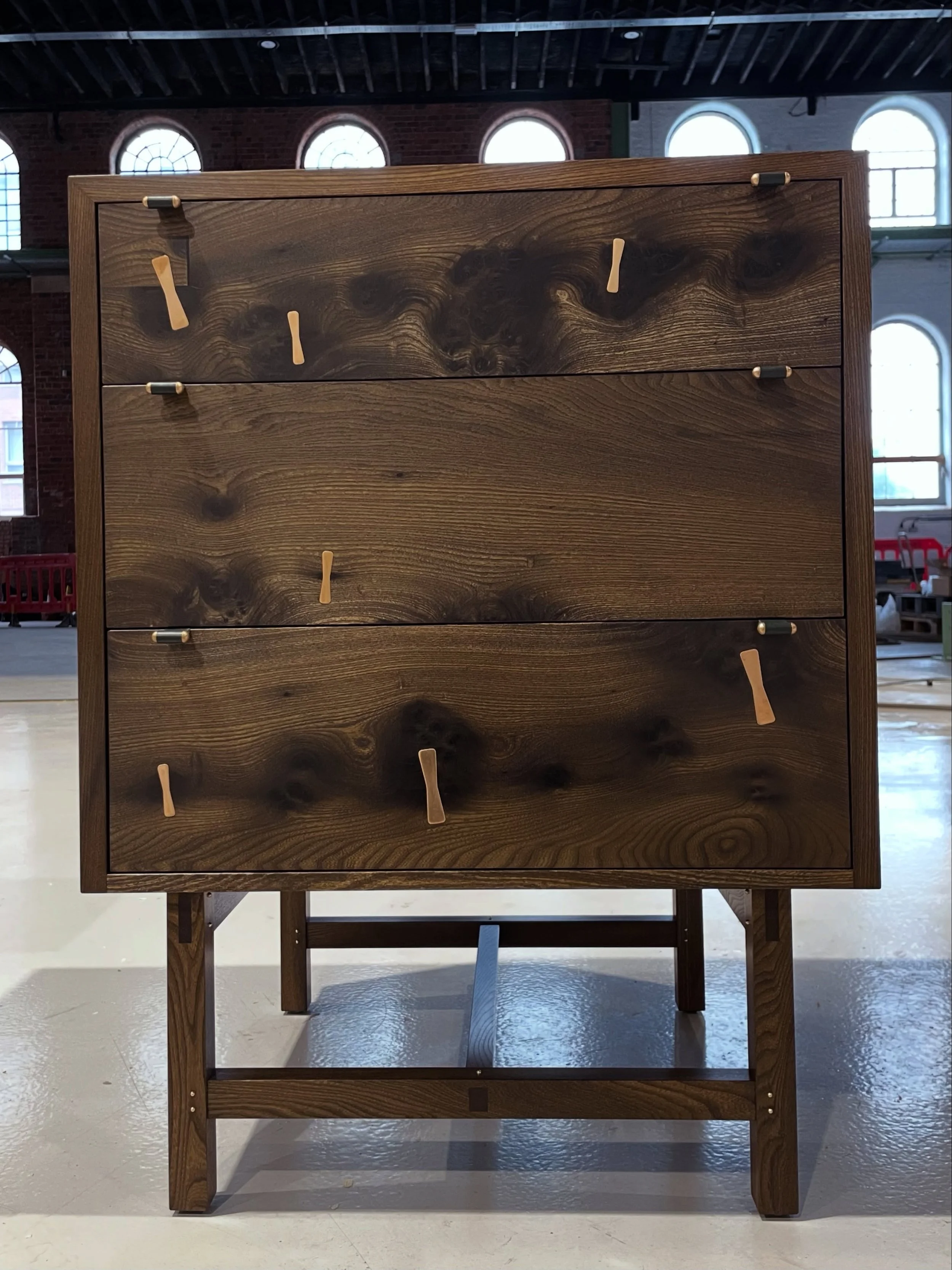 MORA 

Function meets style.

Crafted from solid Scottish elm with a oxidised finish, this chest of drawers showcases beautifully inlaid bronze butterfly keys, a striking detail that highlights the natural beauty of the wood.

Made in Scotland 🏴󠁧󠁢