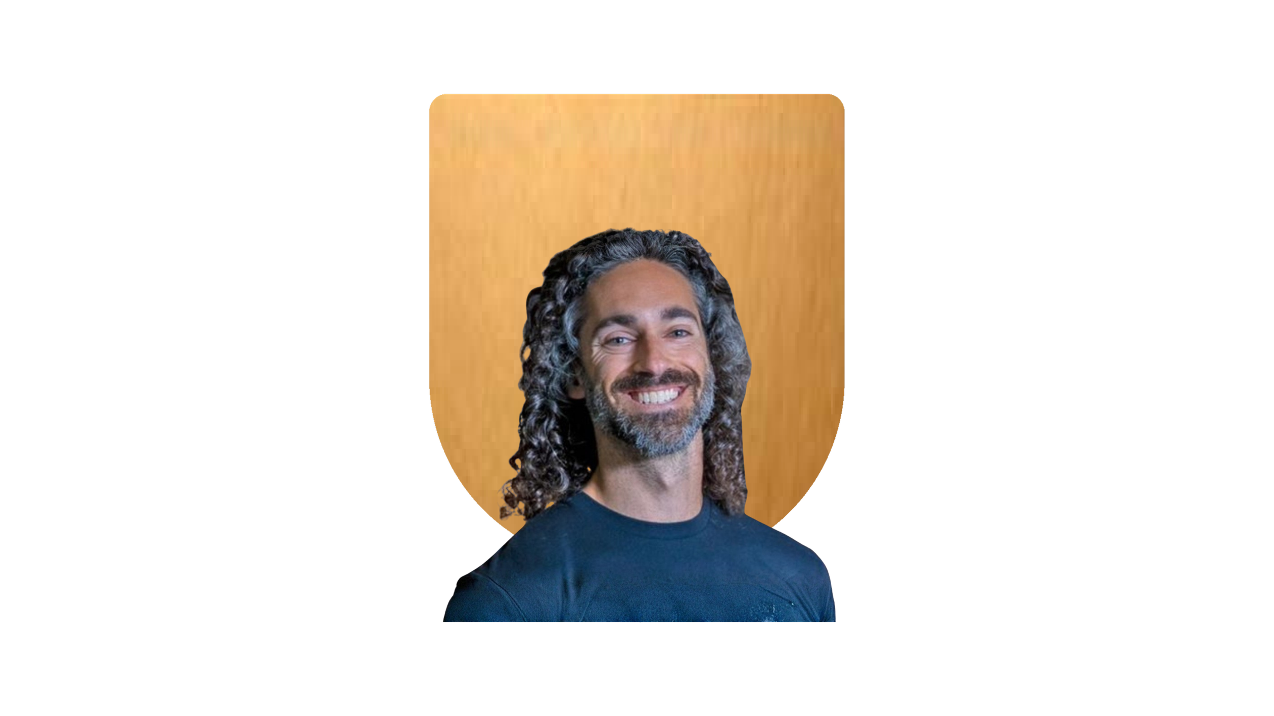 Photograph of a smiling man with curly dark hair and beard, wearing a dark shirt, set against a wooden background.