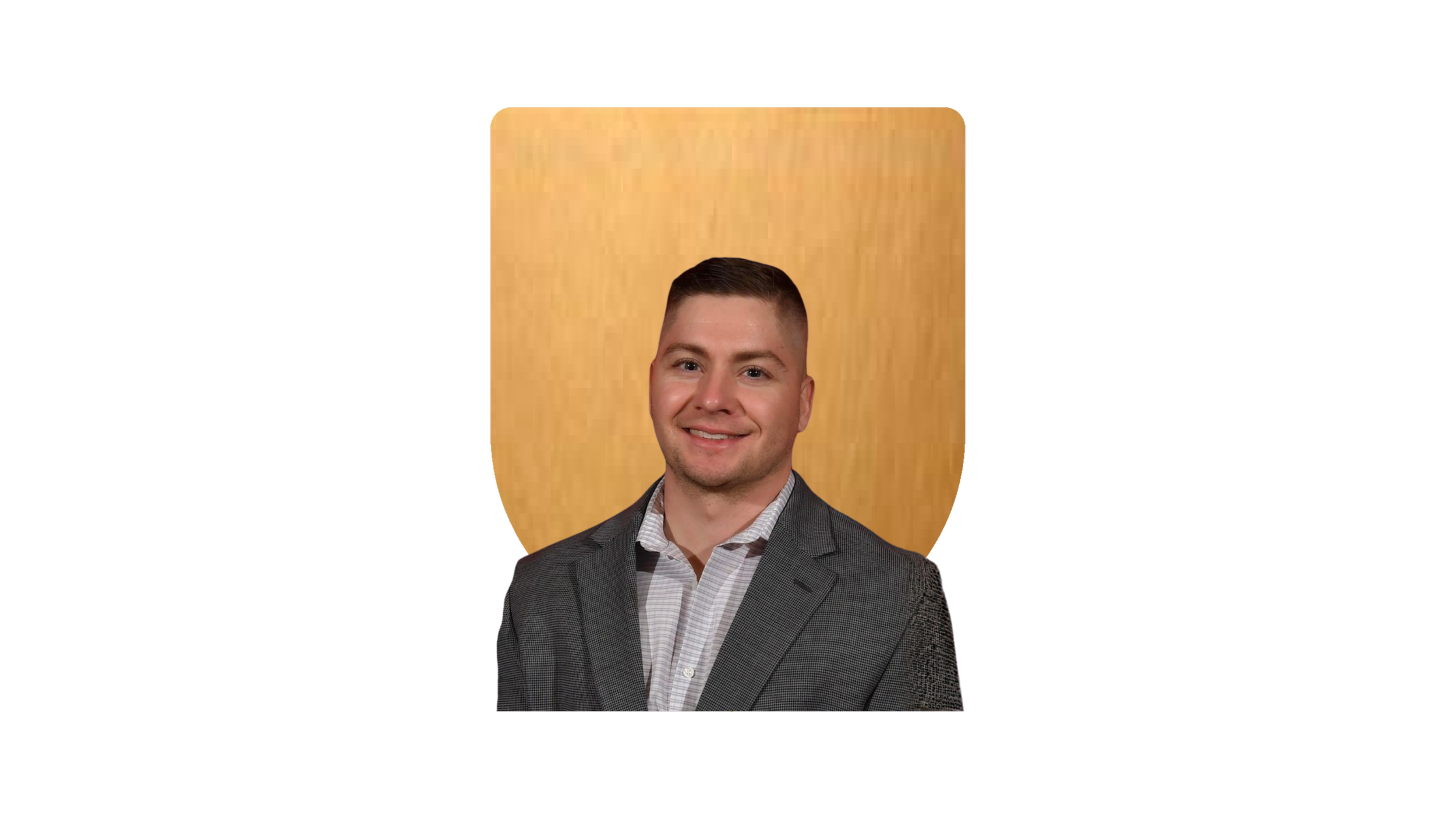 Man in gray suit and blue tie smiling against a wooden background.