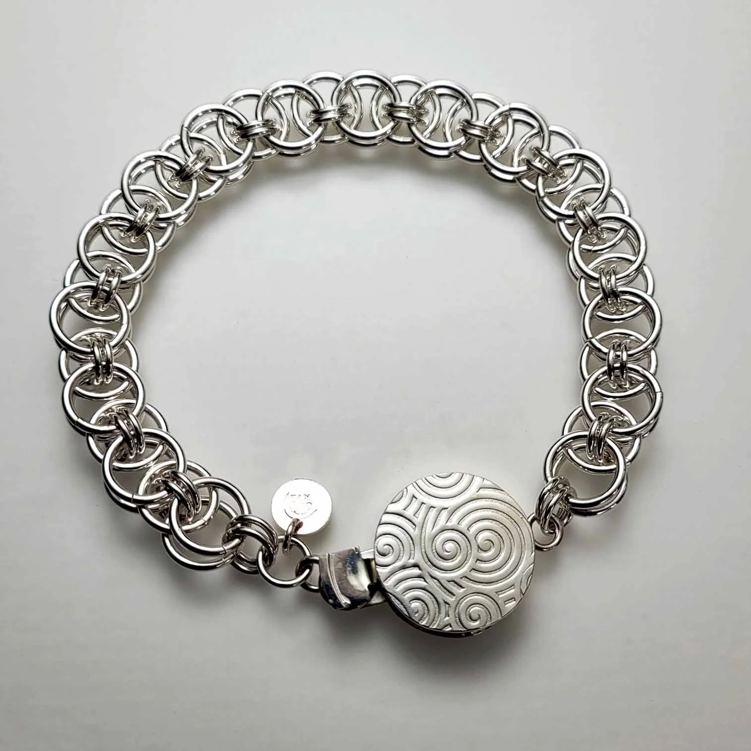 Sterling silver chain-maille bracelet with round box clasp.