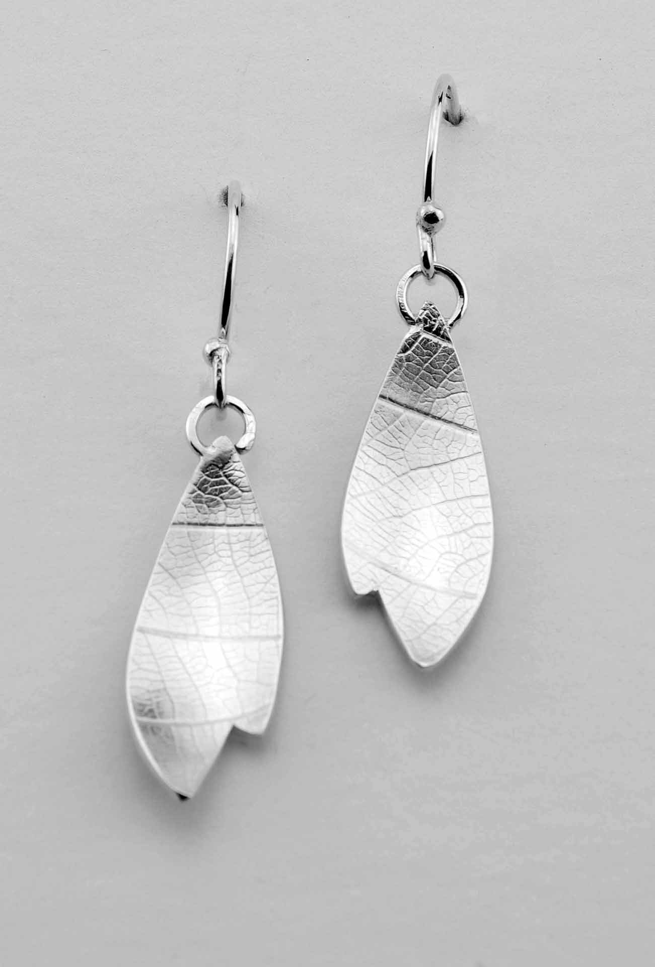 Leaf-shaped drop earring hand-fabricated in sterling silver, embossed with a vein pattern.