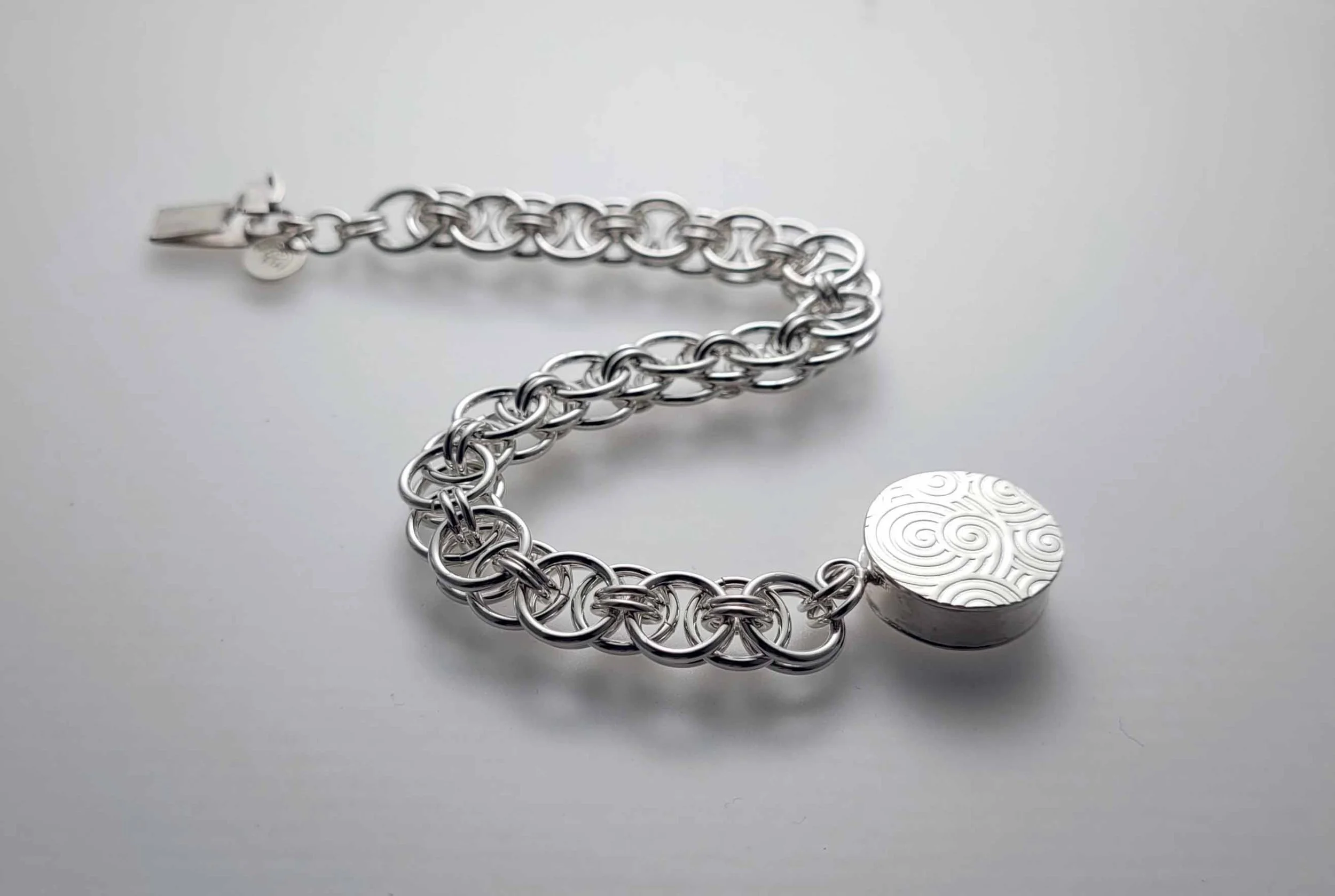 Sterling silver chain-maille bracelet with round box clasp.
