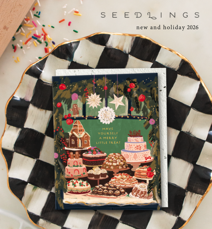 Flat lay of botanical and floral seed packet designs, greeting cards, a ruler, paper clips, and crafting tools on a white table, with text "Seedlings Summer 2025" at the top.