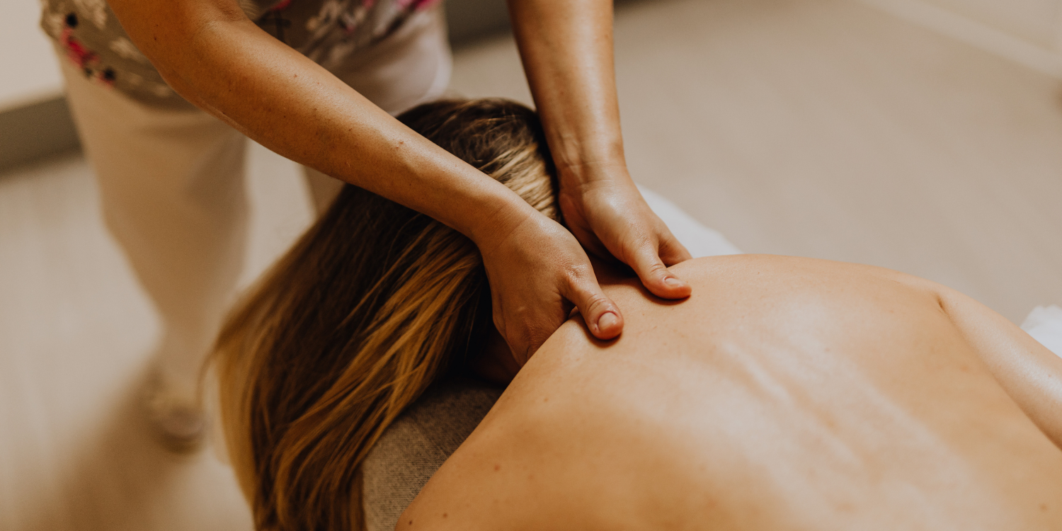 Person receiving a massage on their back from a massage therapist.