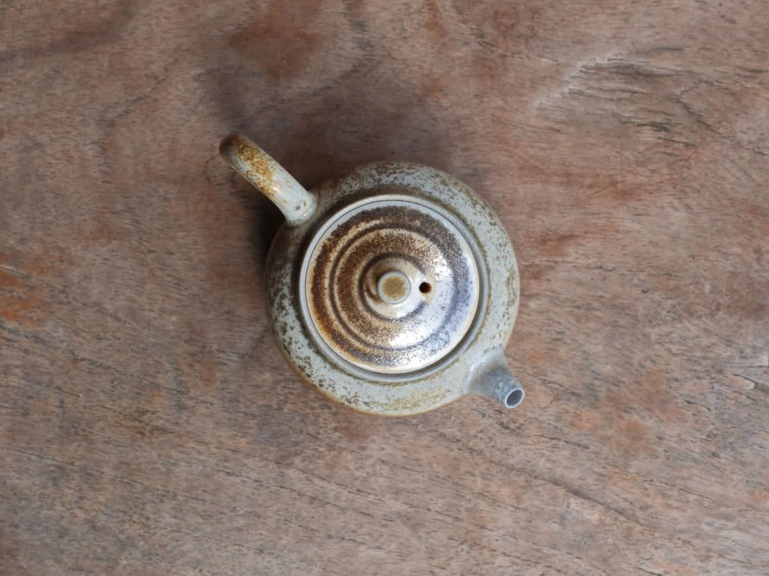 Overhead view of a Taiwanese teapot, spiral lid and softly glazed surface speaking to artisan care and everyday ritual