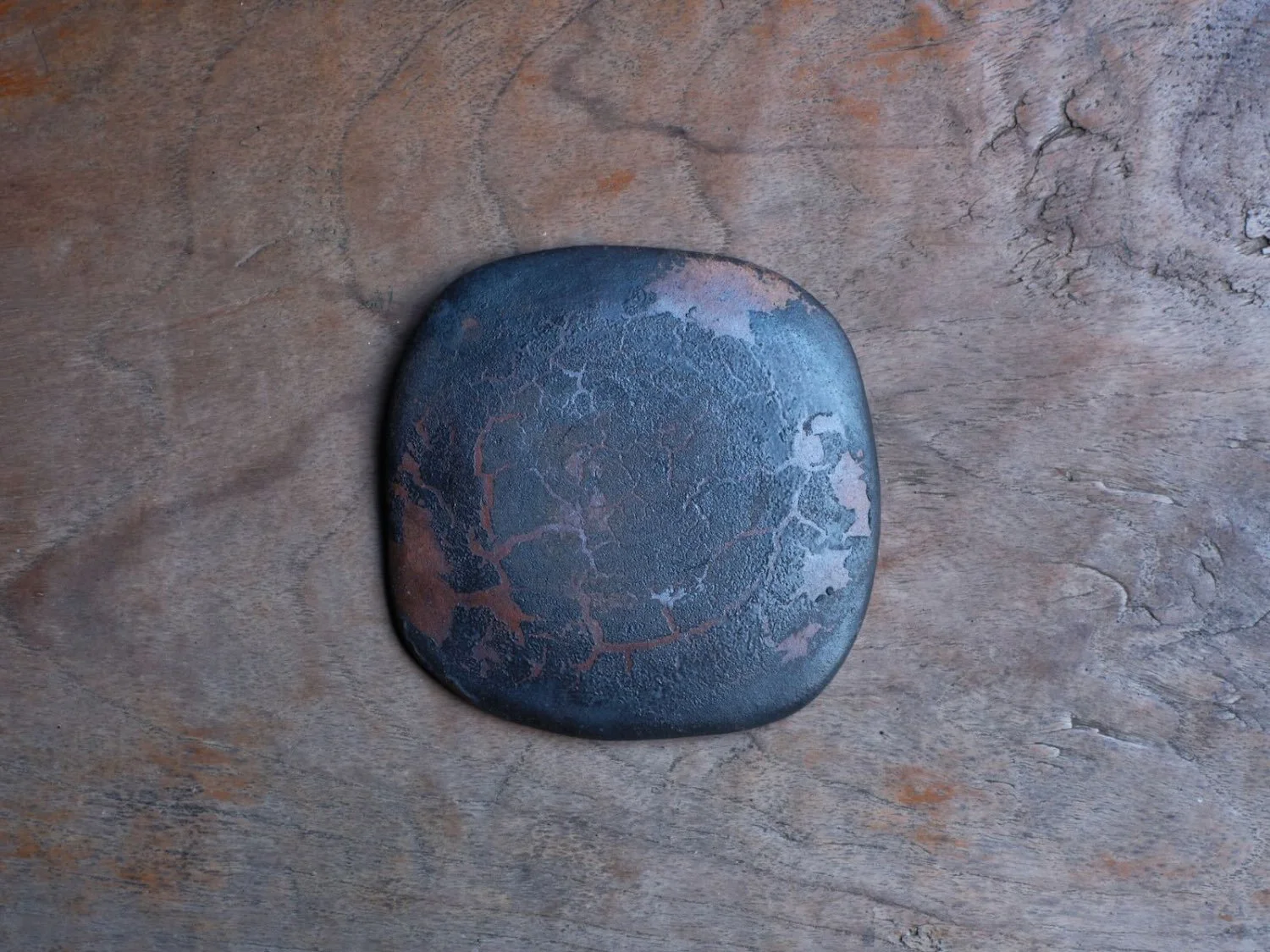 Contemporary Japanese ceramic plate by Yoshimitsu Ishihara, displayed flat to highlight its unique texture and metal-based glaze