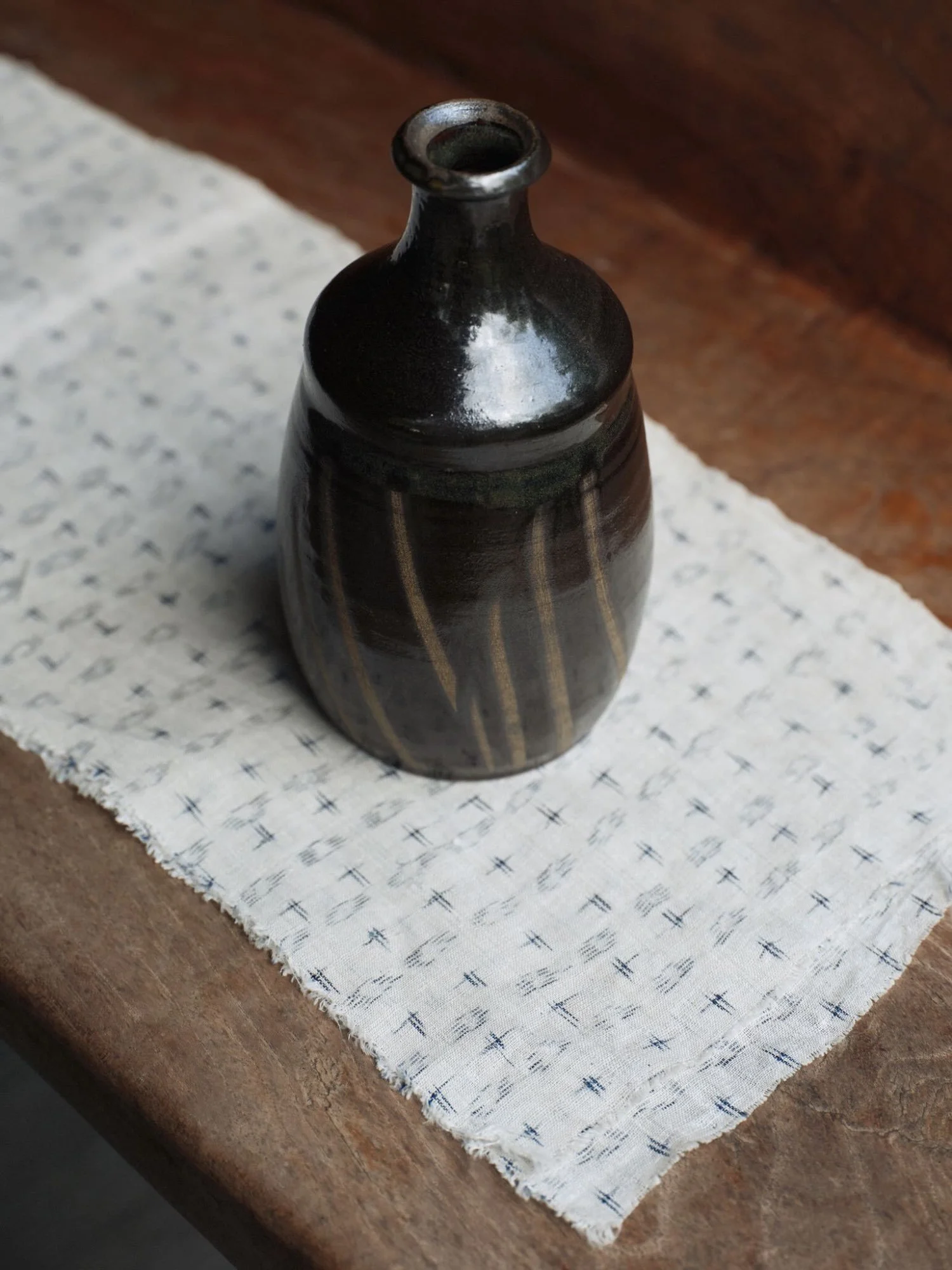 japanese pottery vessel, view from above. the vessel produced in Onta Village, Japan is presented on an old white Japanese textile.