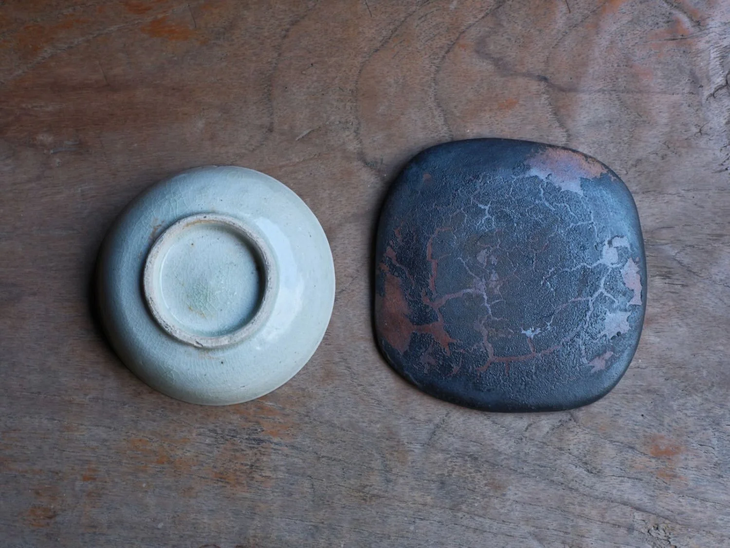 Base view of a Lê Period Vietnamese vessel and contemporary Japanese tray, revealing distinct glazes and foot designs from both cultures
