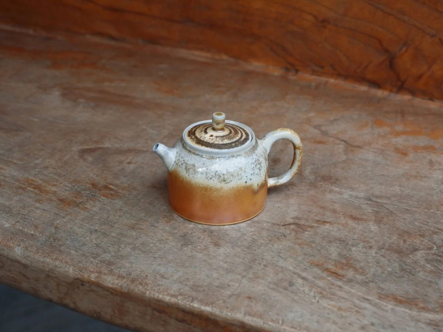 Delicate Taiwanese teapot shown from an angle, highlighting the harmonious blend of spout, handle, and fitted lid