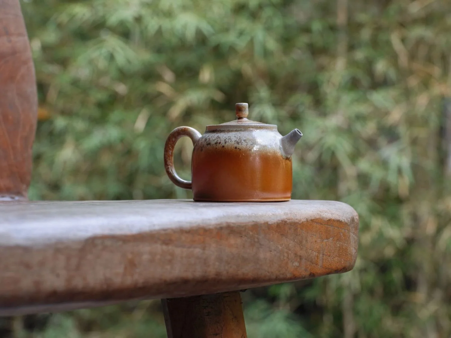 Taiwanese ceramic teapot resting on wood, golden and white glaze catching the soft early morning light, inviting quiet reflection