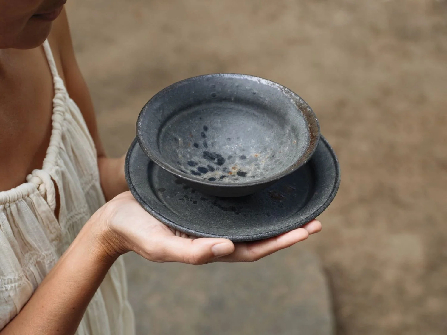 bowl and plate handcrafted by Kan Ito held delicately in woman hands
